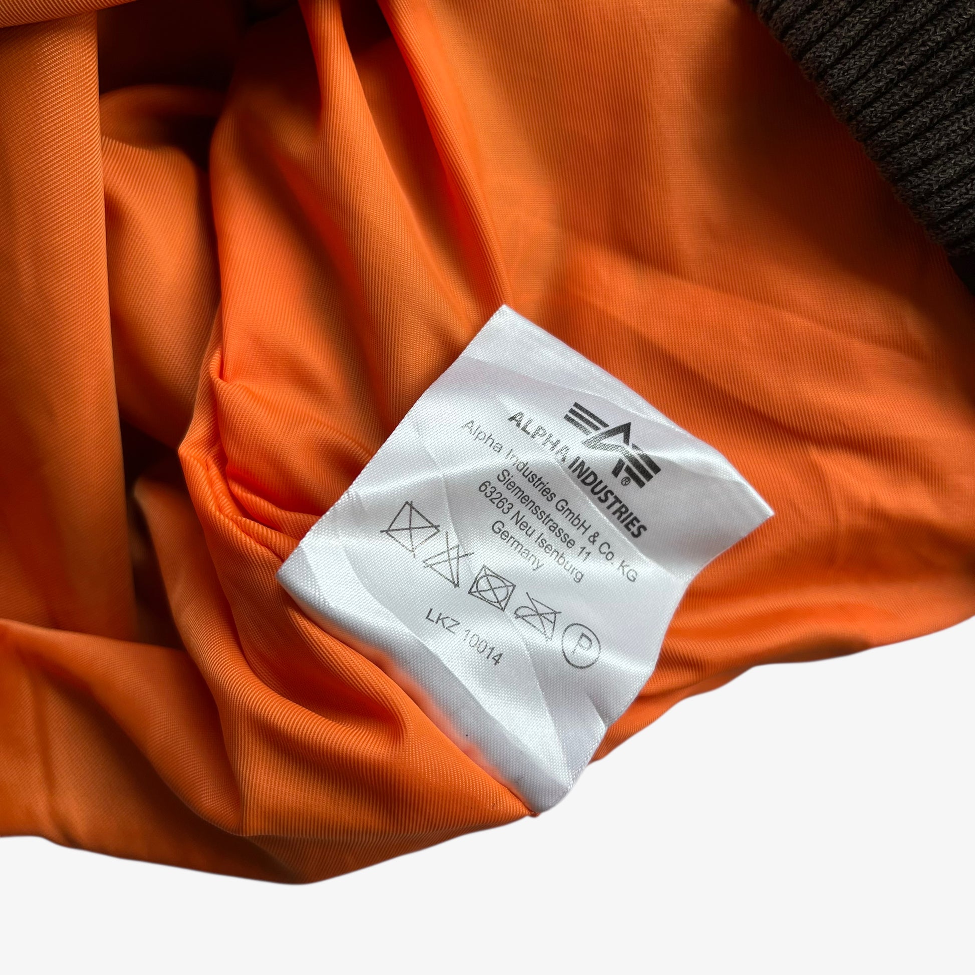 Inside label of men's vintage Y2K Alpha Industries black bomber jacket.