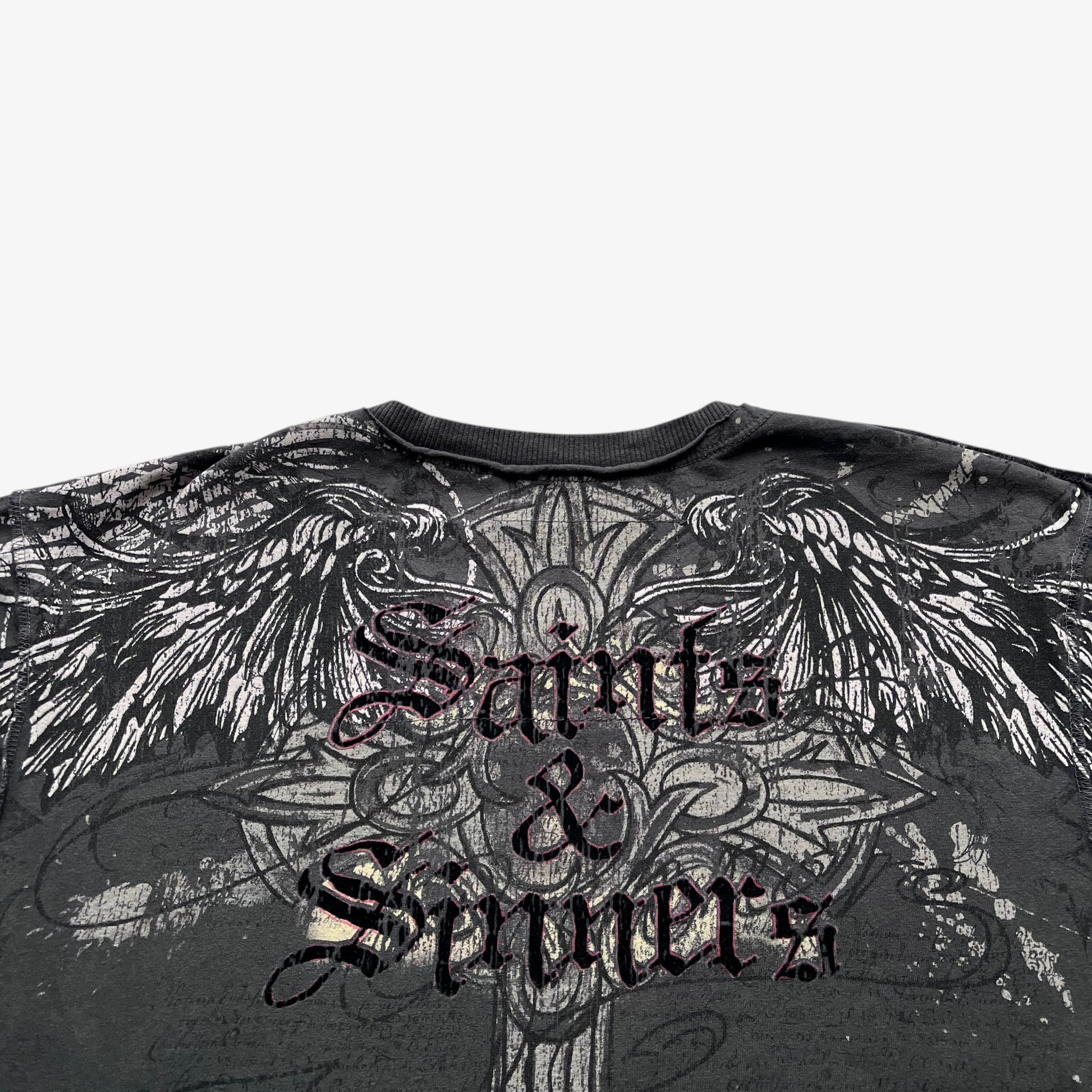 Close up of a saints and sinners spell out on the back of a men's vintage grey t-shirt.