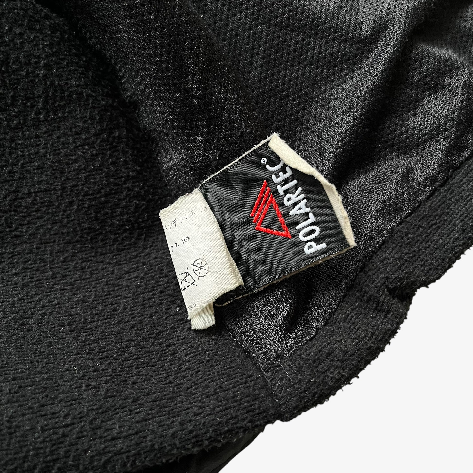 Polartec label stitched inside of men's vintage Y2K Arcteryx black hooded utility jacket.