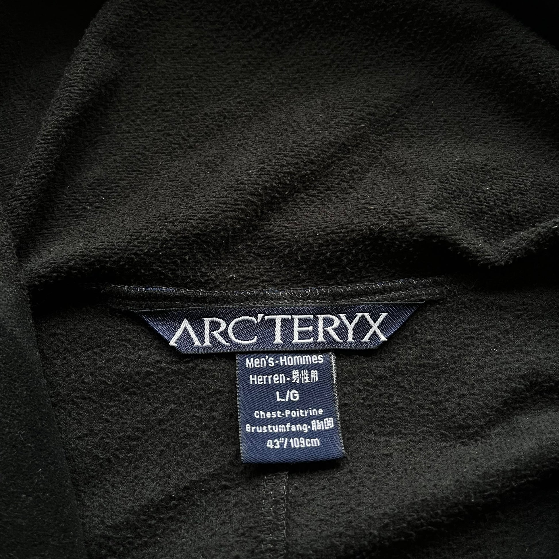 Arcteryx label stitched inside of men's vintage Y2K Polartec black hooded utility jacket.