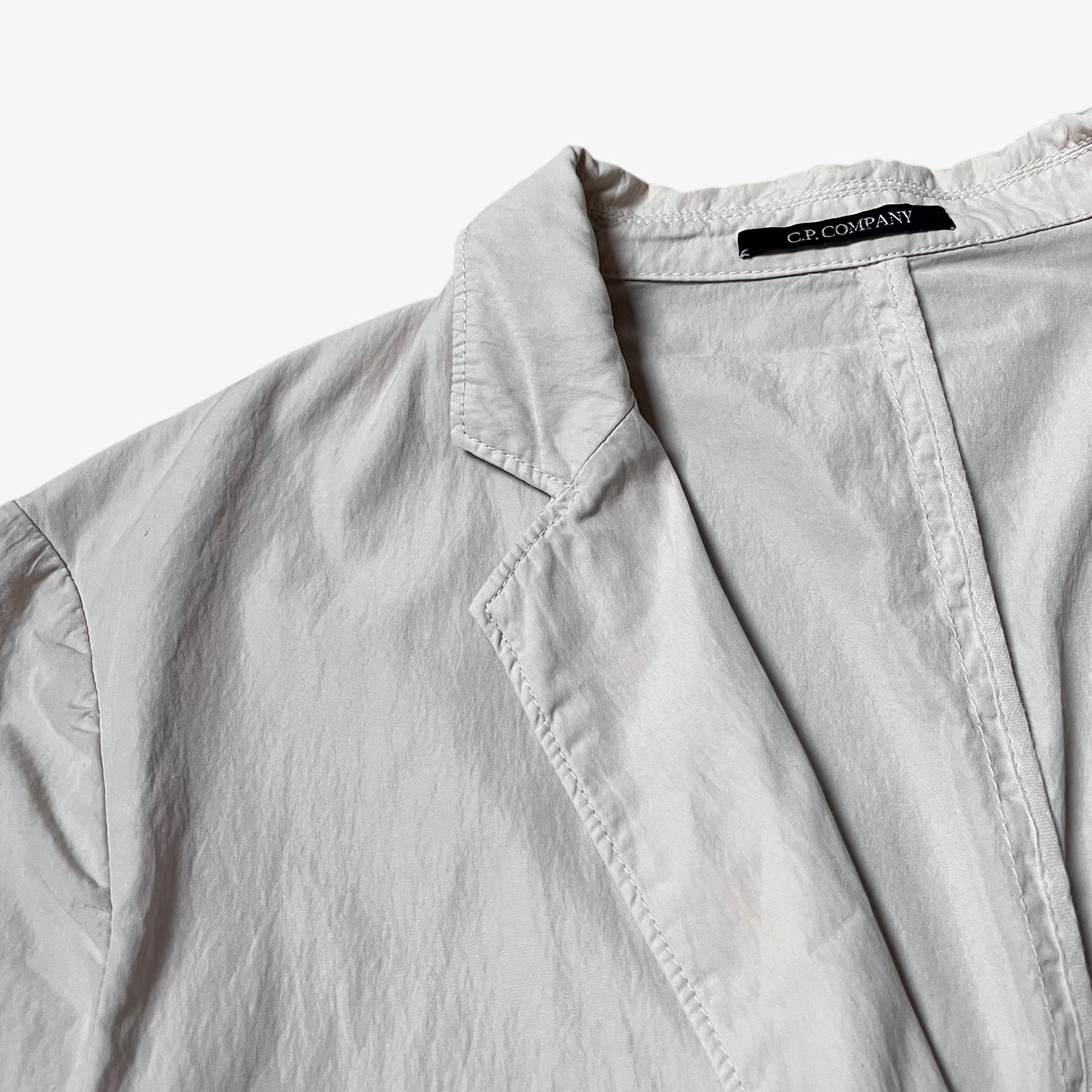 Close up of collar on vintage Y2K men's CP Company cream single breasted blazer.