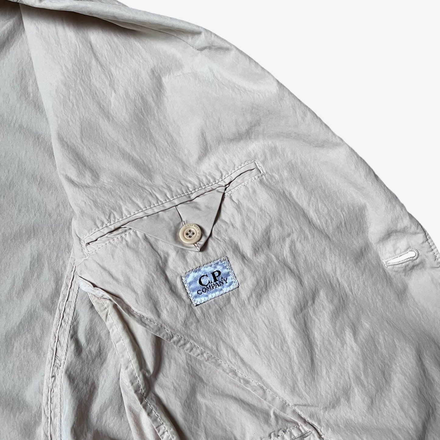 CP Company zig zag stitched label inside of a vintage Y2K men's cream single breasted blazer.