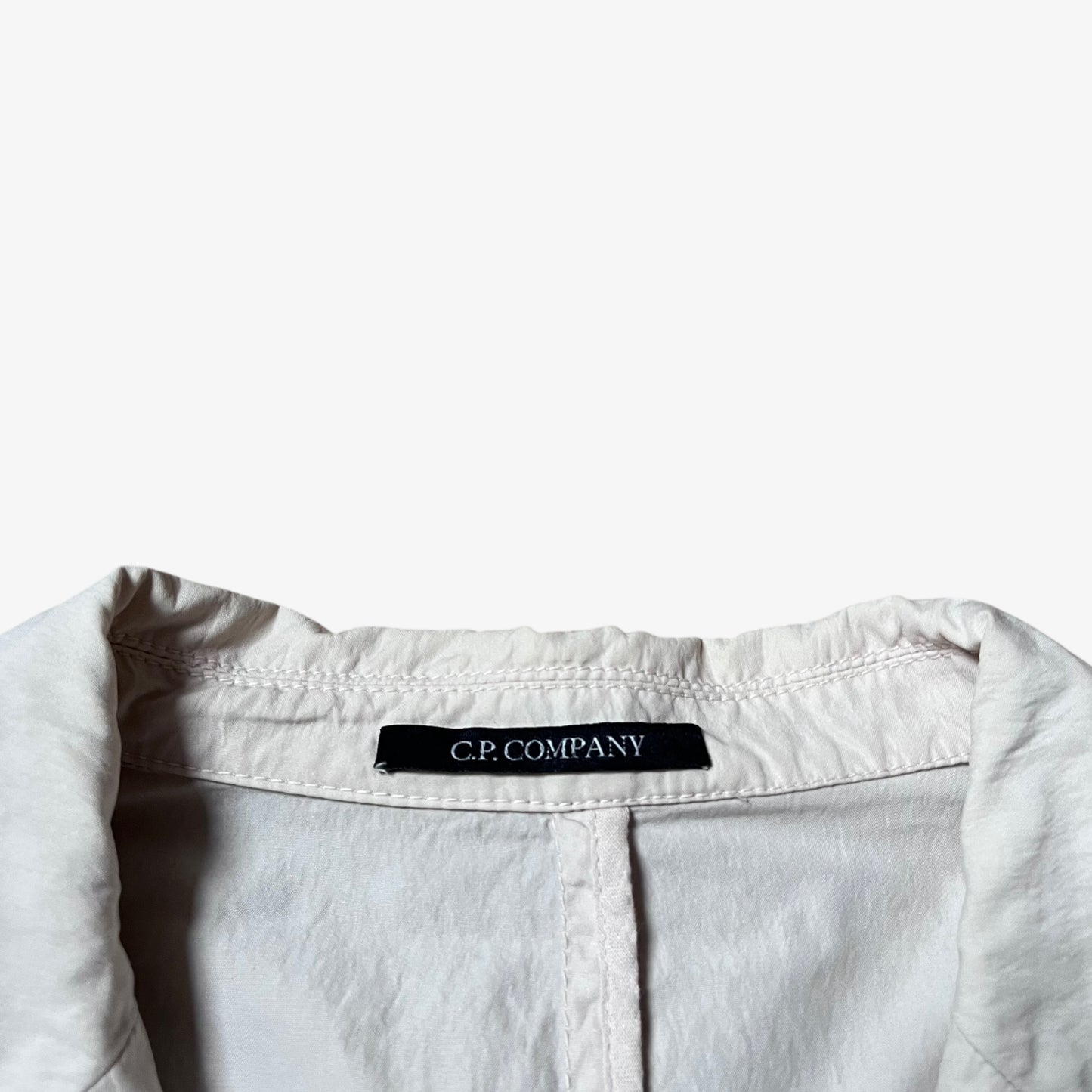 CP Company stitched inside of the neck of a vintage Y2K men's cream single breasted blazer.