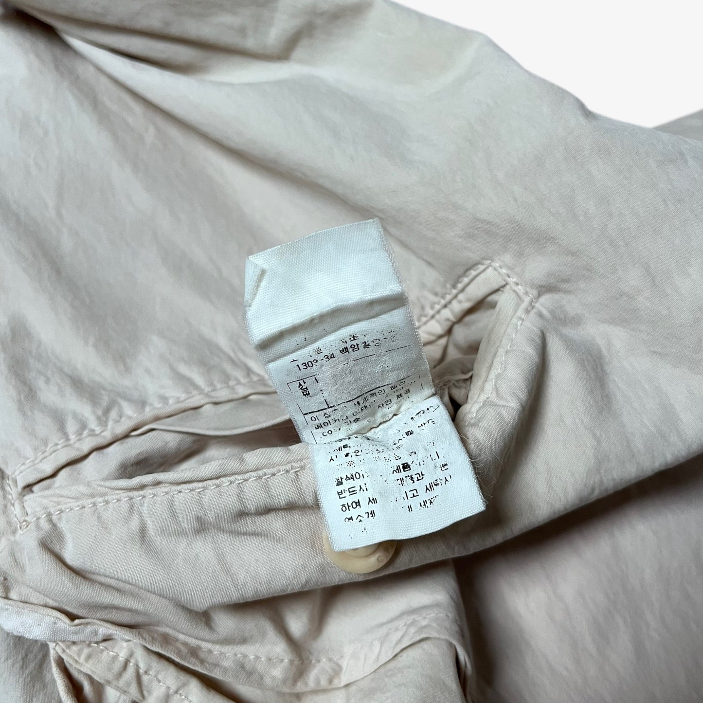 Inside label of vintage Y2K men's CP Company cream single breasted blazer.