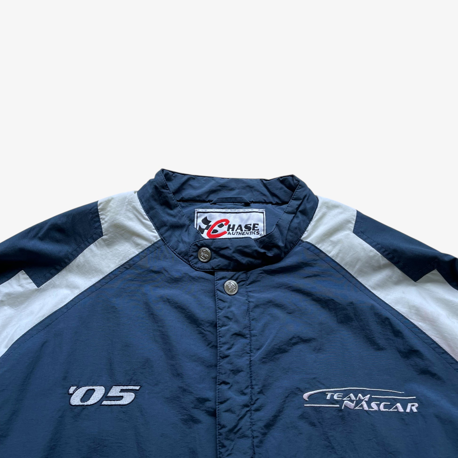 Embroidered spell outs on men's vintage Y2K Chase Authentics 2005 team nascar blue jacket.