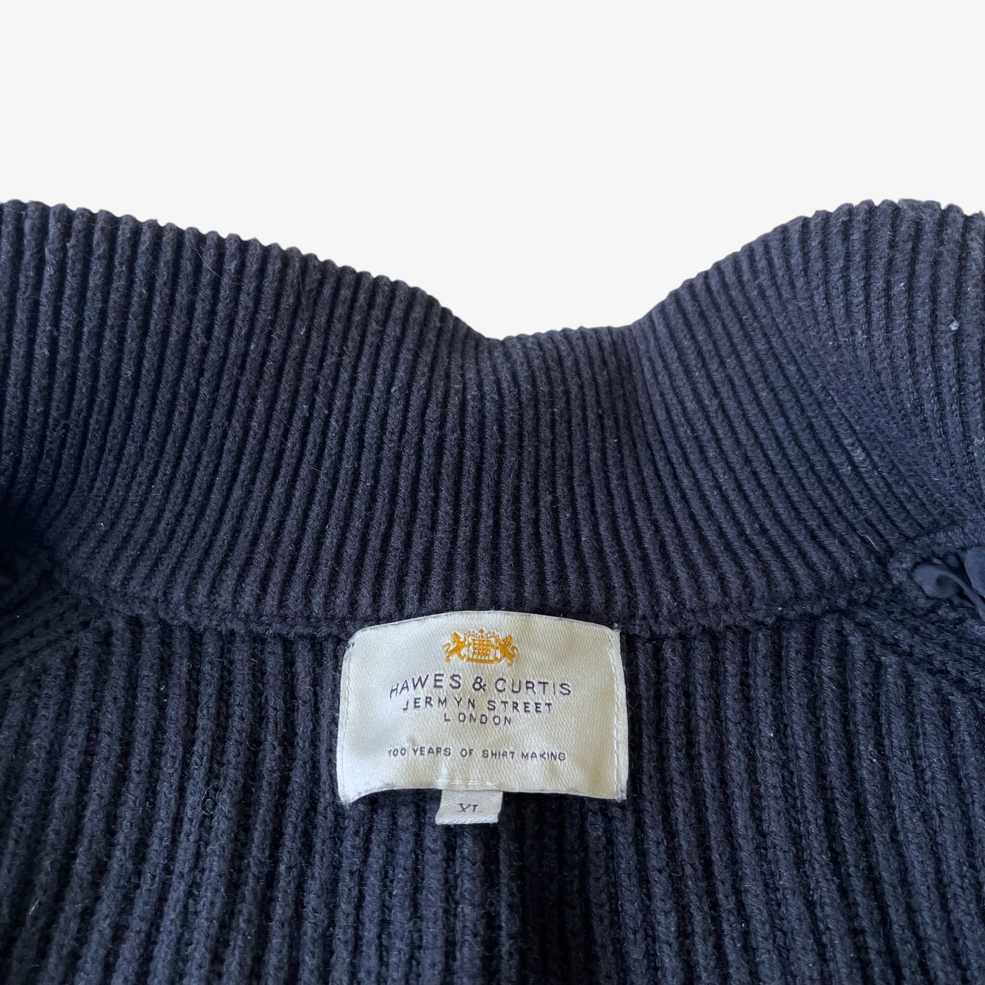 Close up of a Hawes and Curtis label stitched inside a vintage black quilted puffer gilet.