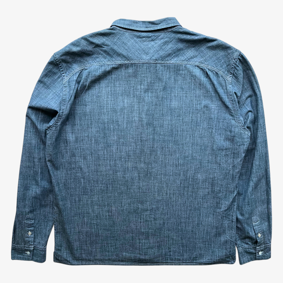 Back of vintage Y2K men's Paul Smith faded blue denim shirt on a white background.