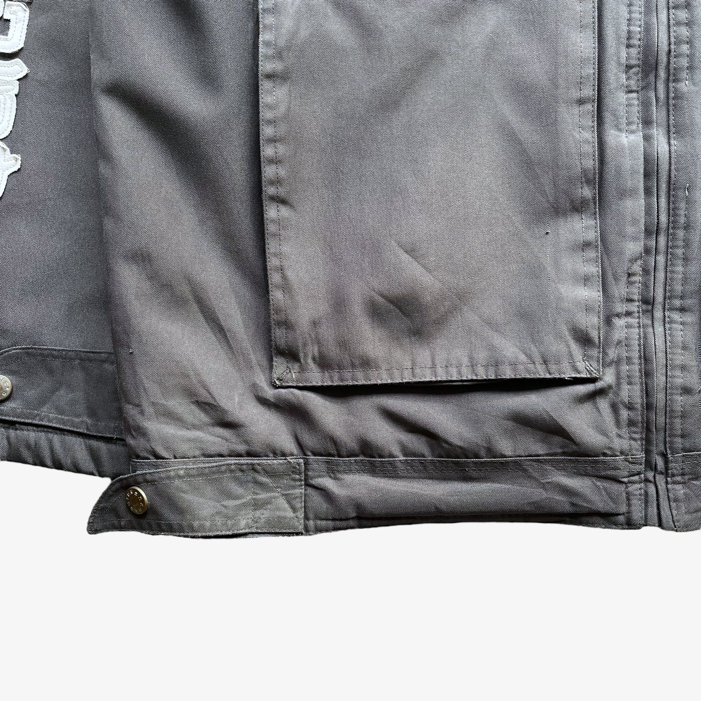 Cargo pockets of men's vintage Y2K Quickshark special aircraft supply grey utility jacket with back spell out.