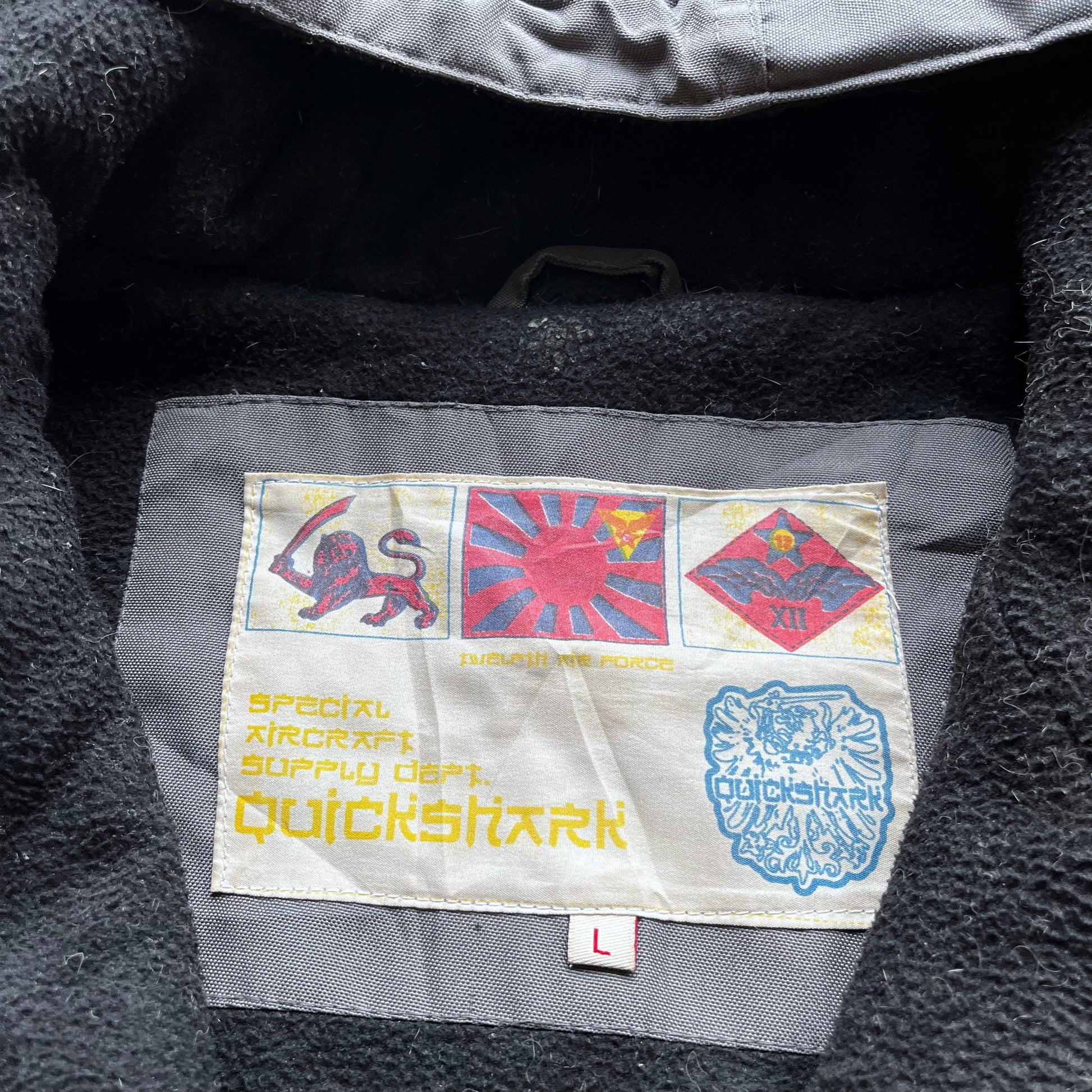Quickshark label stitched inside of men's vintage Y2K special aircraft supply grey utility jacket with back spell out.