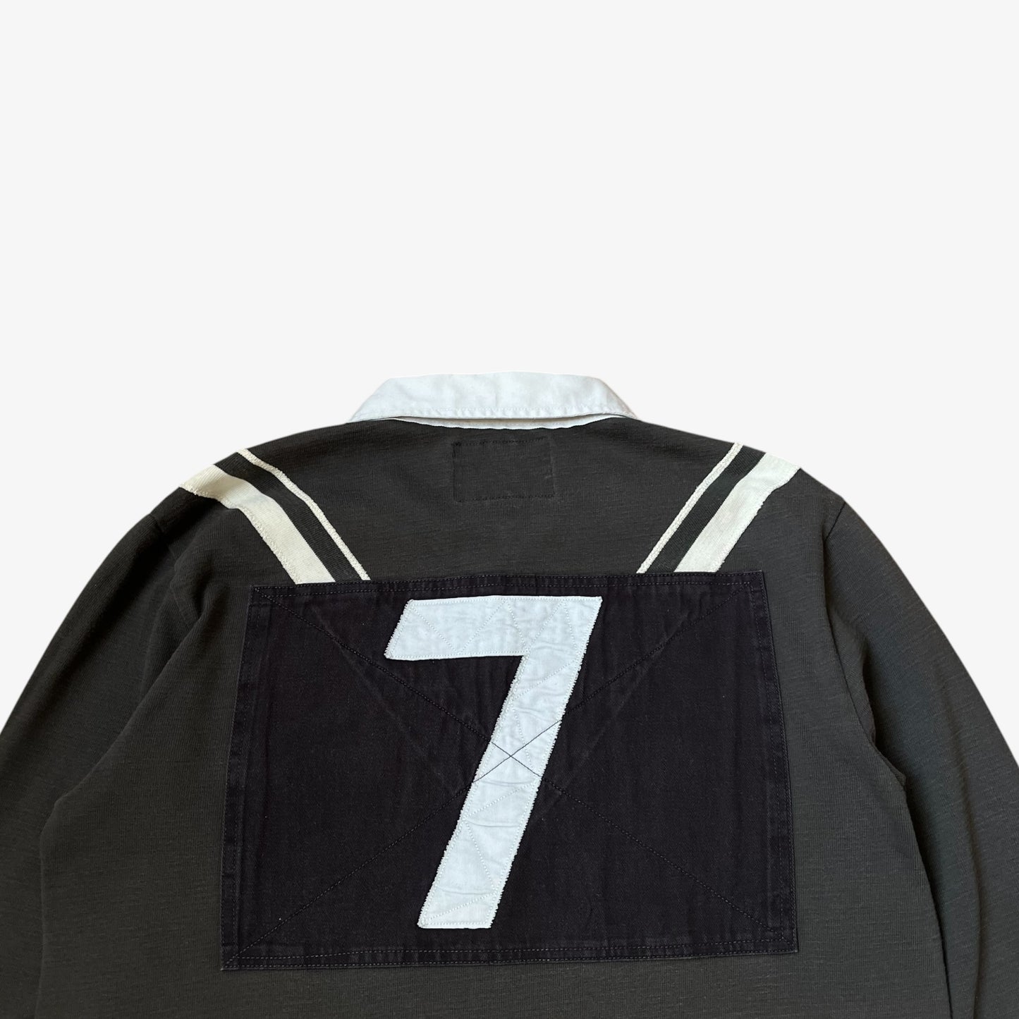 Close up of embroidered 7 on the back of vintage Y2K men's Ralph Lauren grey rugby shirt.