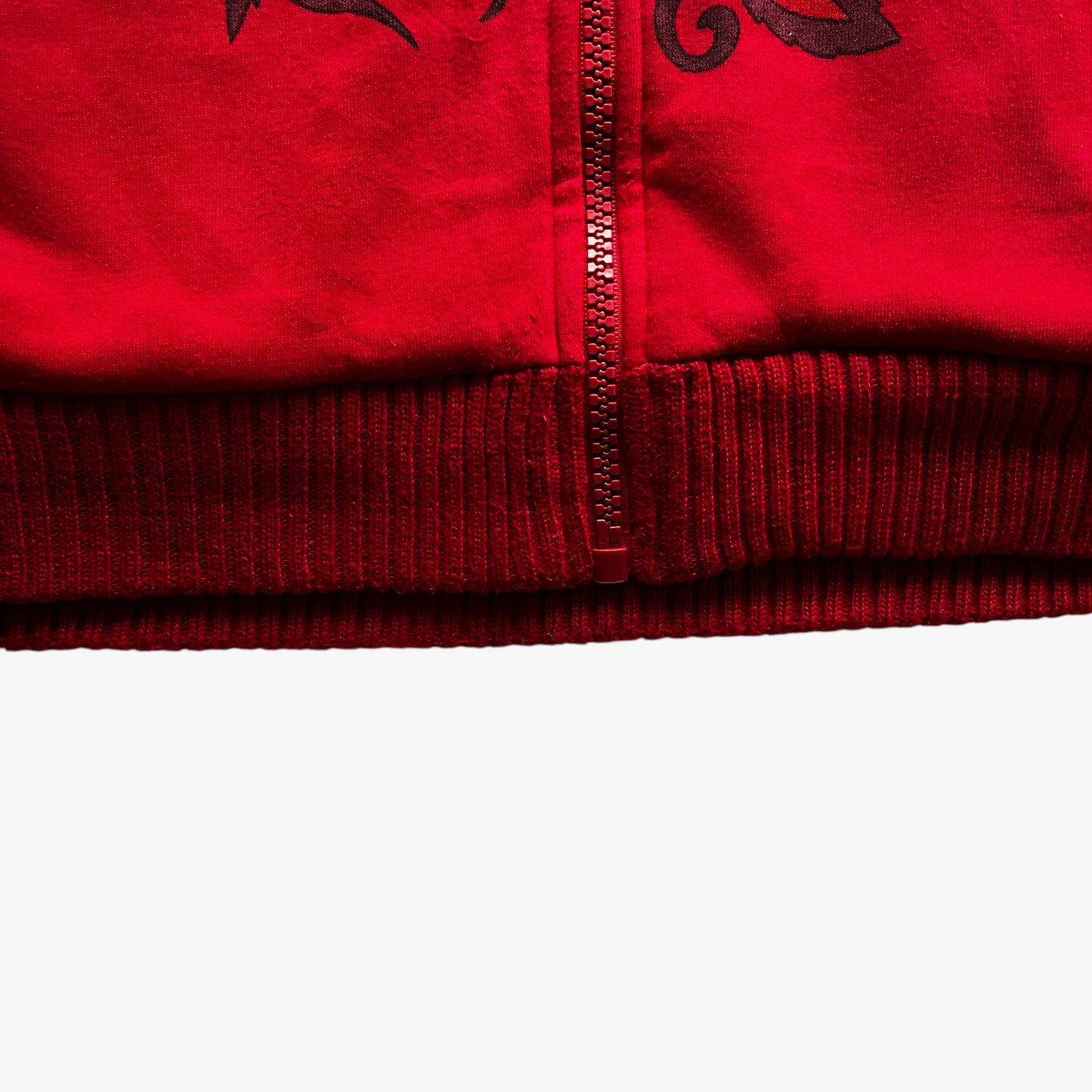 Hem of vintage Y2K men's Really Point rhinestone skull and panther double sided print red jacket.