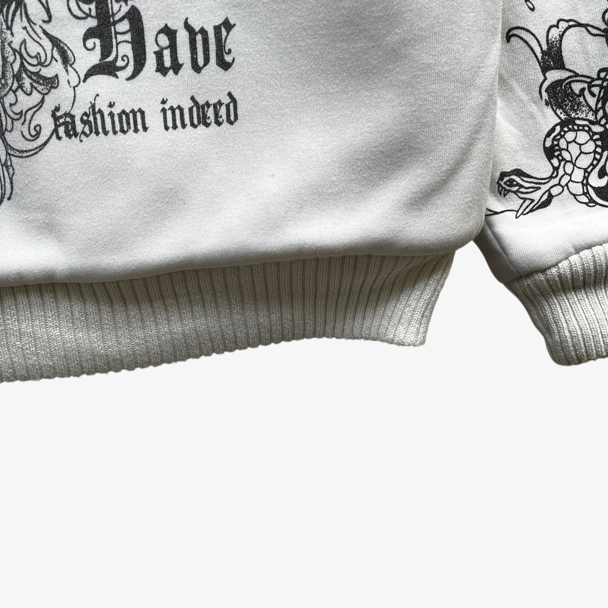 Ribbed hem of vintage Y2K men's Really Point skull and snake double sided print white hooded jacket with sherpa lining.