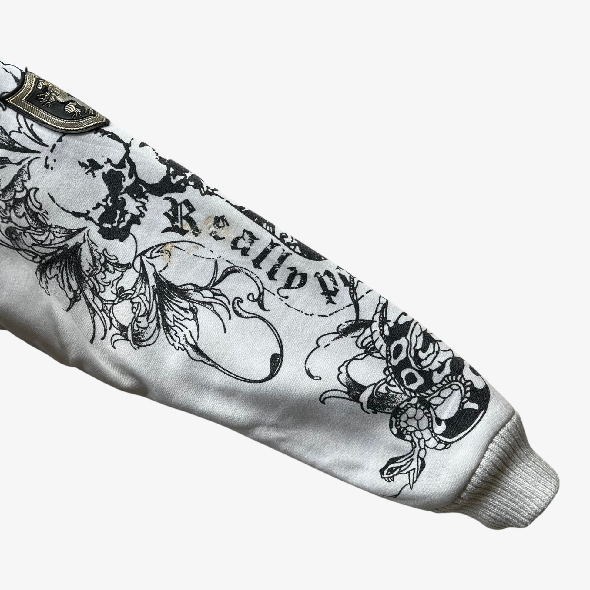 Skull pattern on sleeve of vintage Y2K men's Really Point snake double sided print white hooded jacket with sherpa lining.