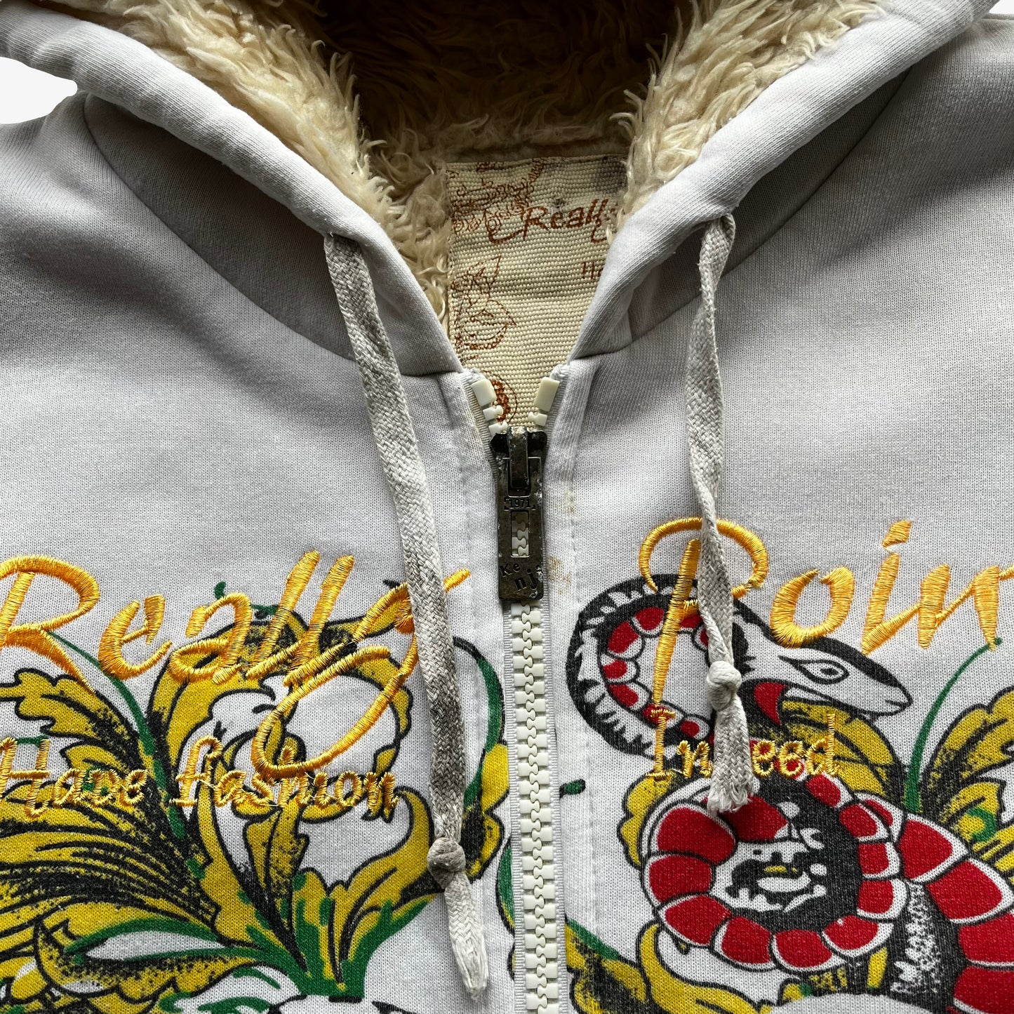 Metal zipper of vintage Y2K men's Really Point skull and snake double sided print white hooded jacket with sherpa lining.