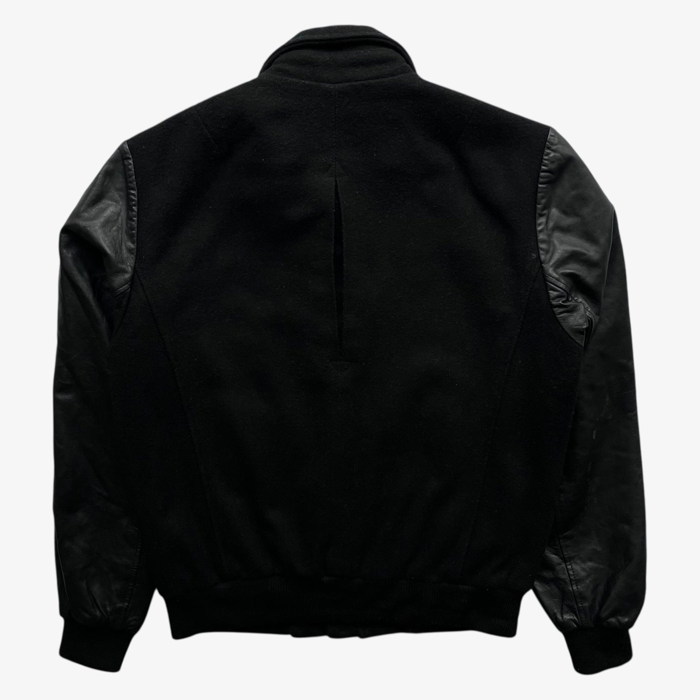 Back of vintage Religion black wool and leather varsity jacket on a white background.