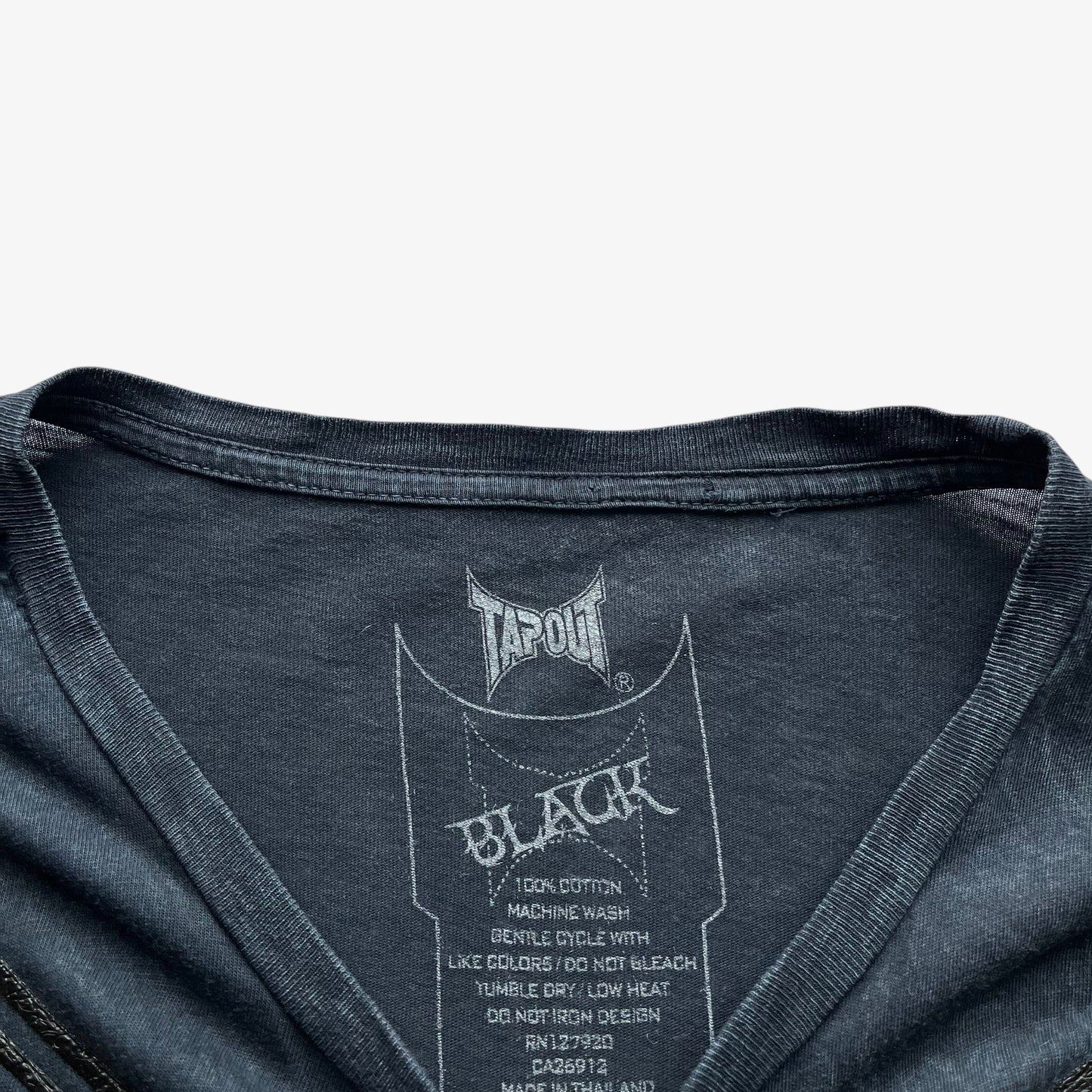 Tapout black line printed label inside of a vintage Y2K men's navy t-shirt.