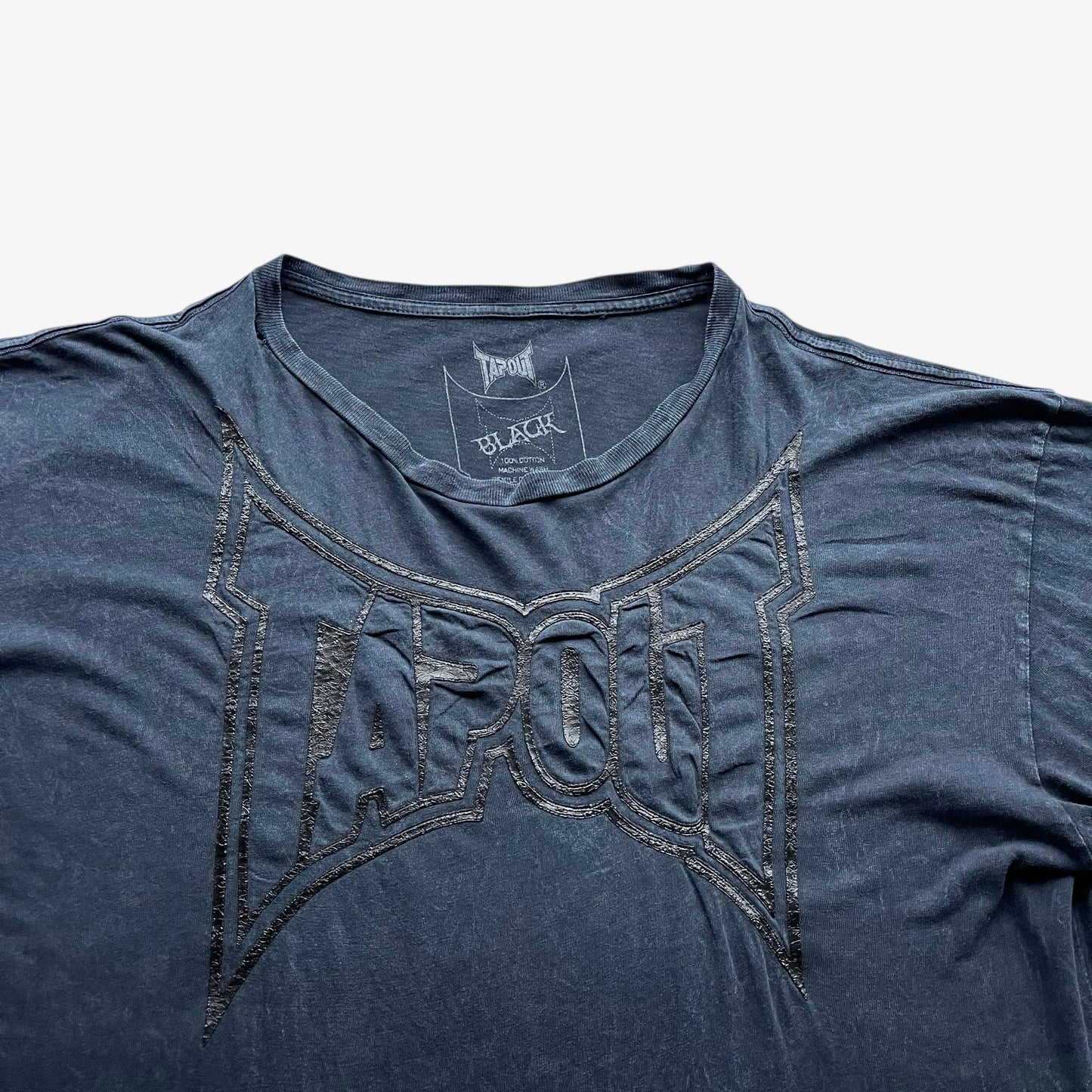 Close up of a 3D embossed Tapout spell out on a vintage men's navy t-shirt.