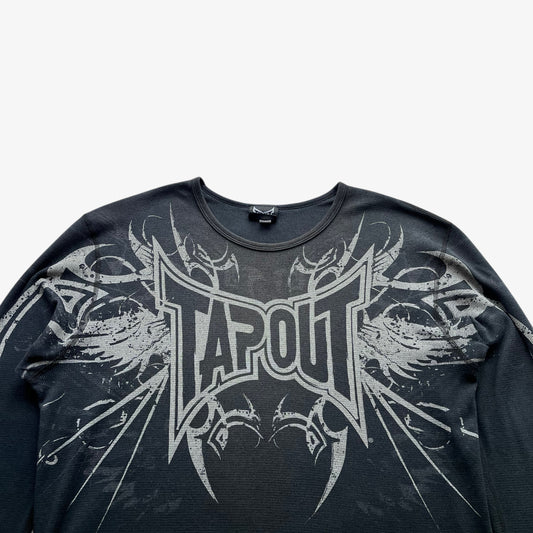 Close up of vintage Y2K Tapout spell out on a long sleeve faded grey t-shirt.