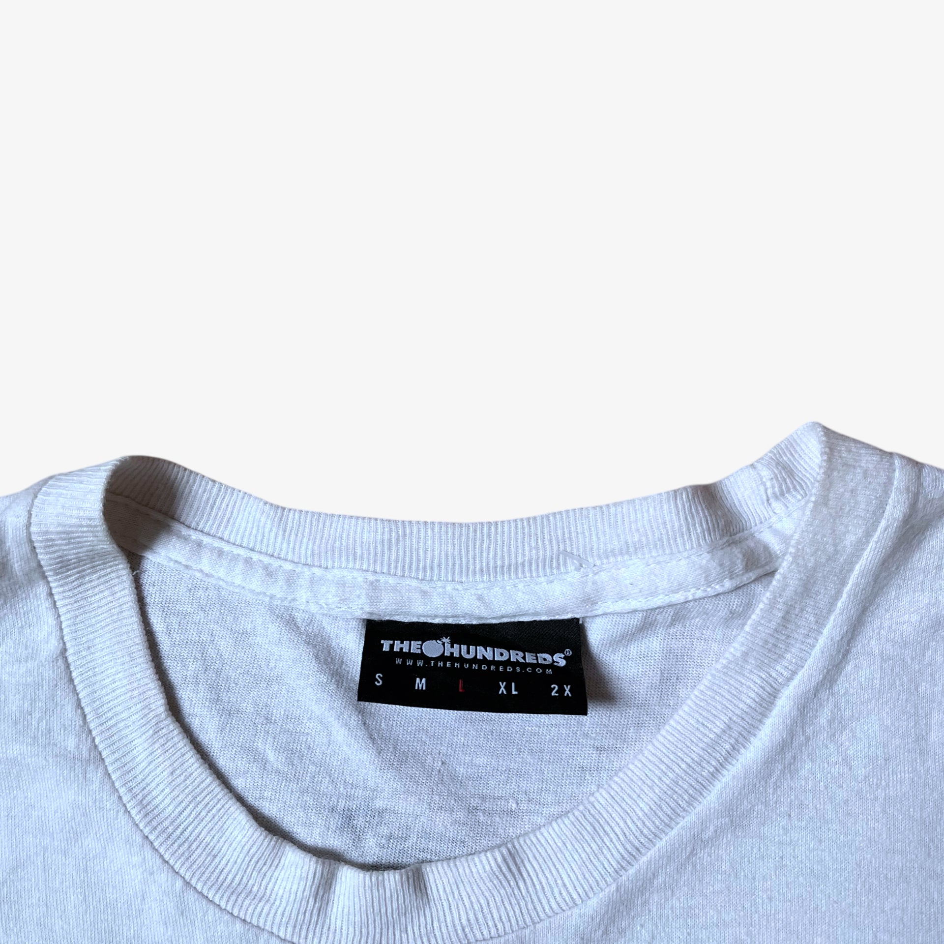 The Hundreds label stitched inside of a vintage Y2K men's Gigi woman print white t-shirt.