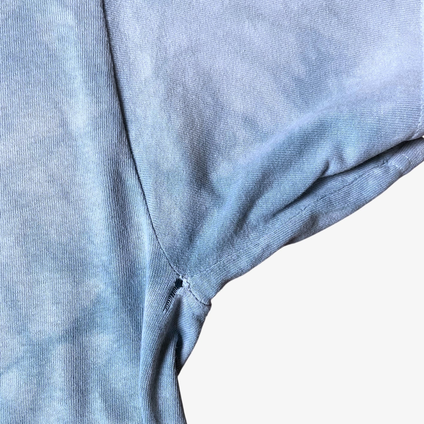 Patina on sleeve of vintage Y2K The Mountain dreams of wolf spirit print blue tie dye t-shirt.