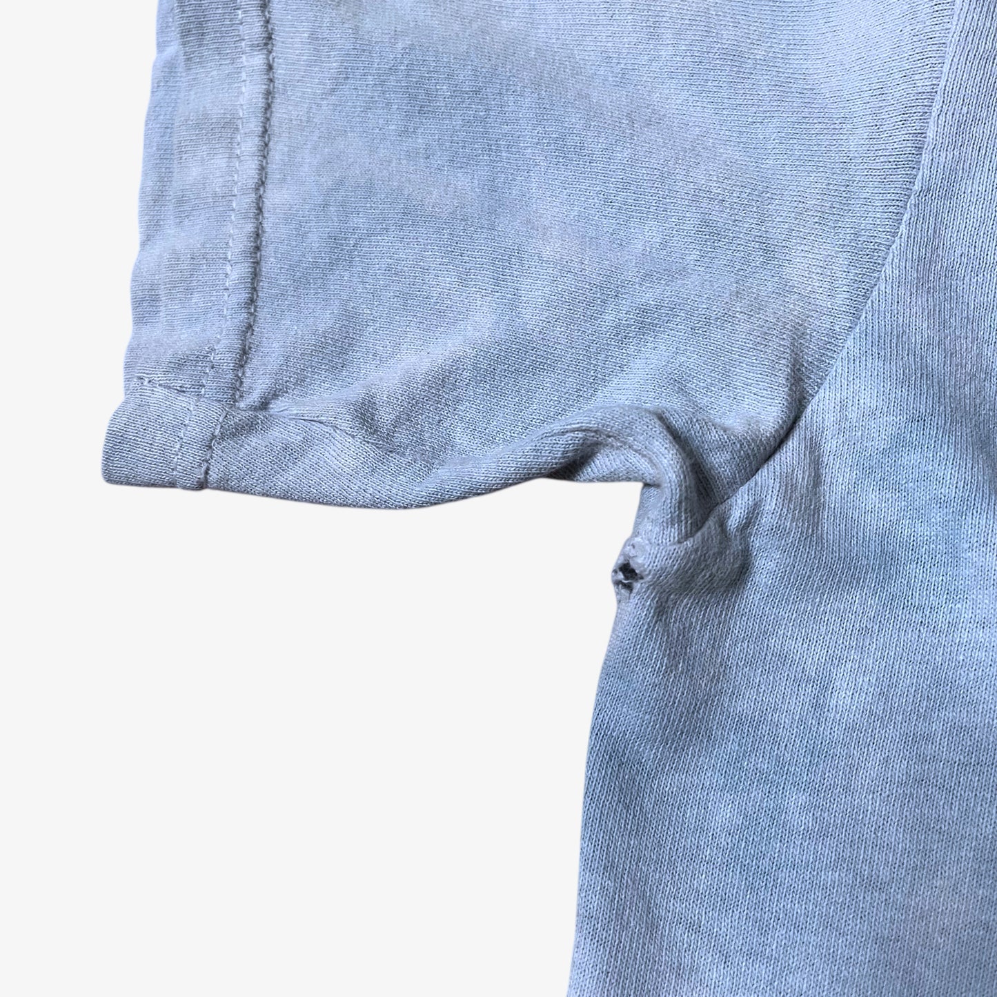 Wear on sleeve of vintage Y2K The Mountain dreams of wolf spirit print blue tie dye t-shirt.