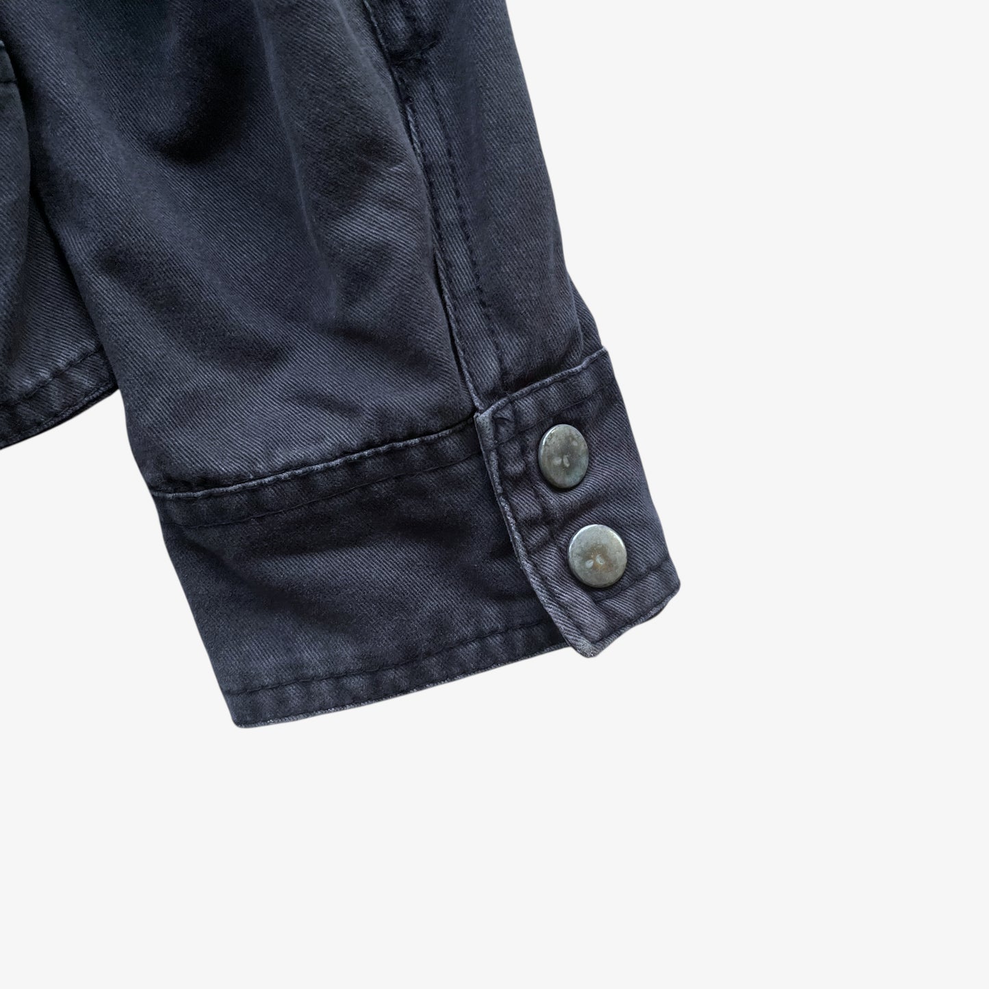 Cuff of vintage Y2K men's US Army 3D E87 faded navy utility jacket.