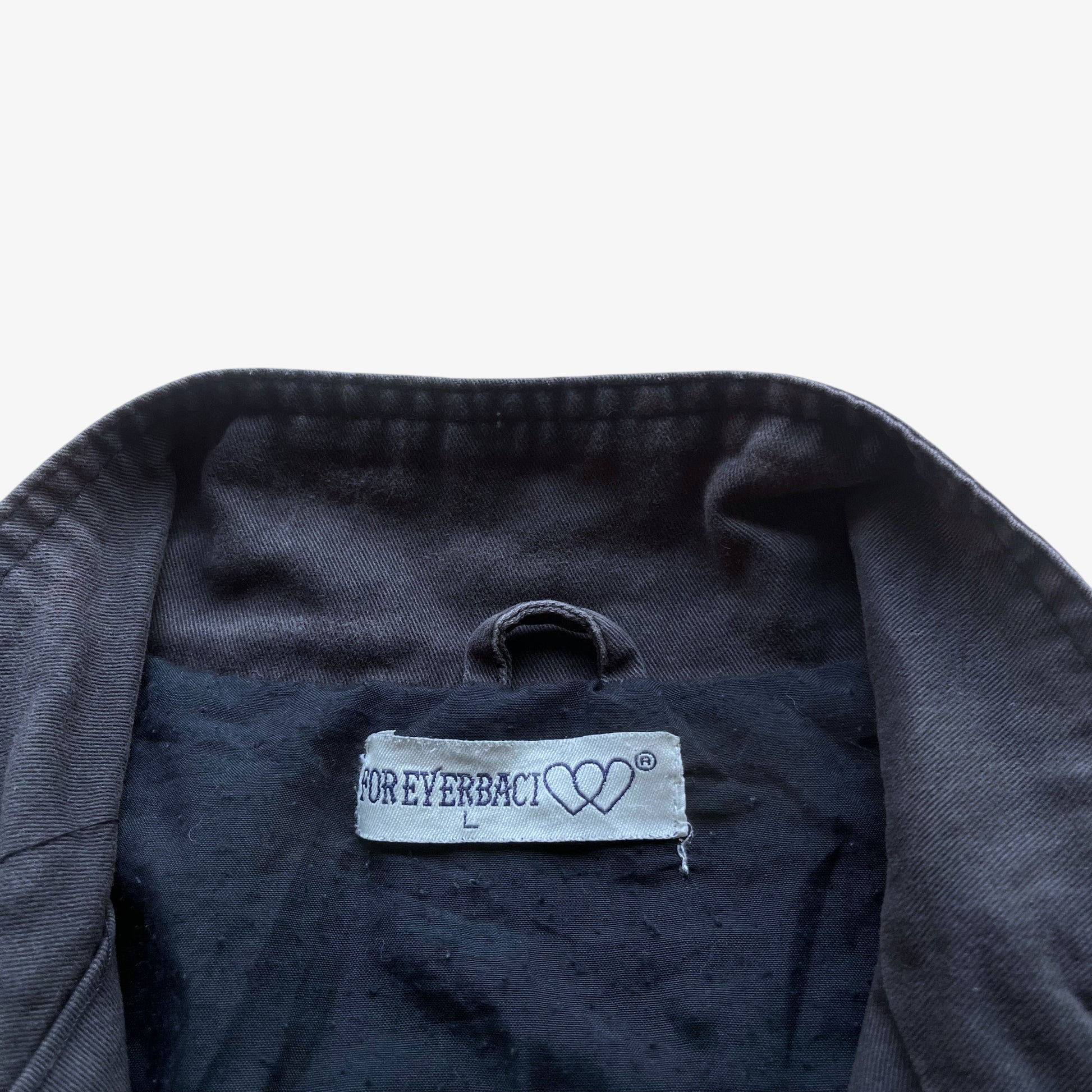 Label stitched inside of vintage Y2K men's US Army 3D E87 faded navy utility jacket.