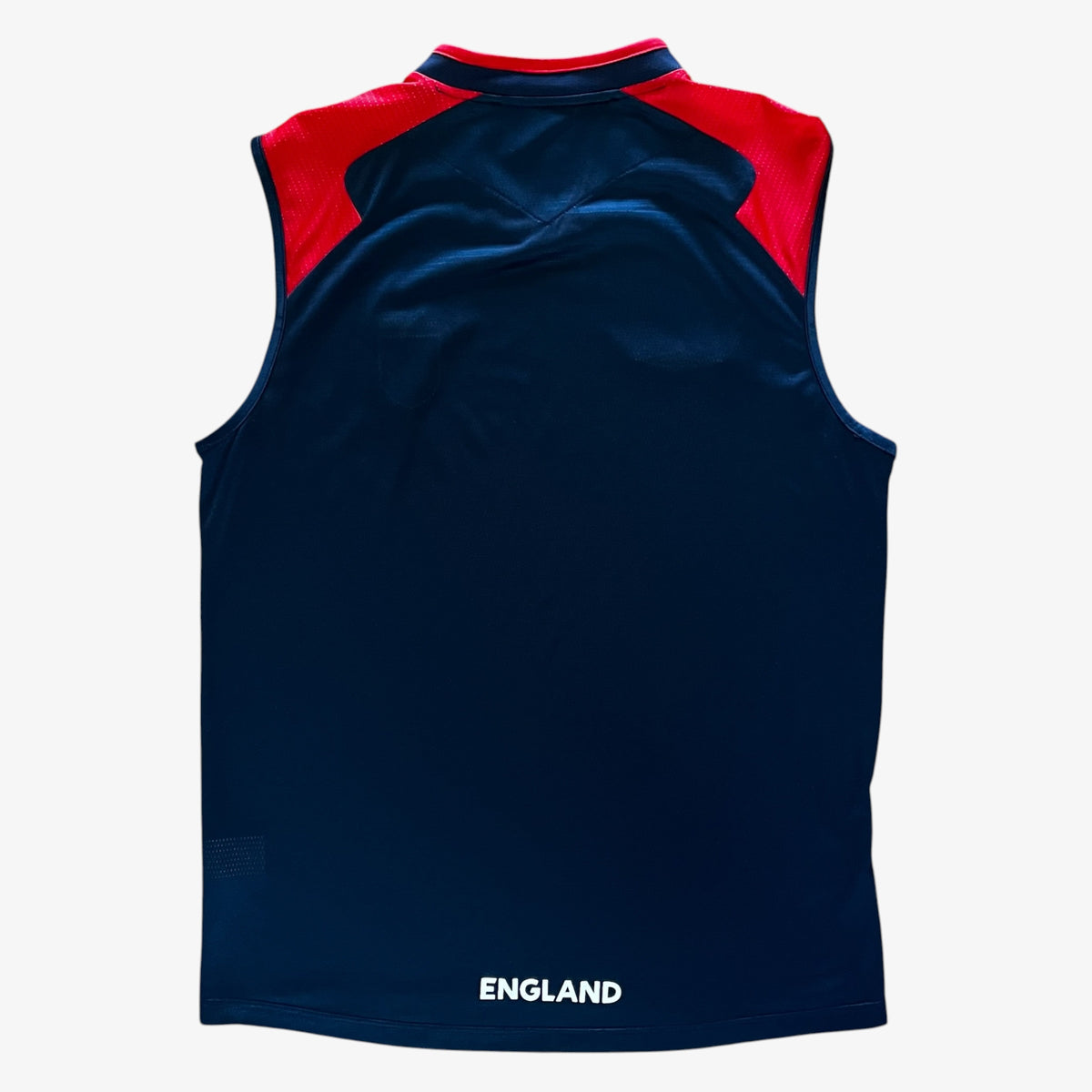 A sleeveless athletic jersey shown from the back, featuring a dark navy blue body with red shoulder panels and a white 'ENGLAND' text print at the bottom.