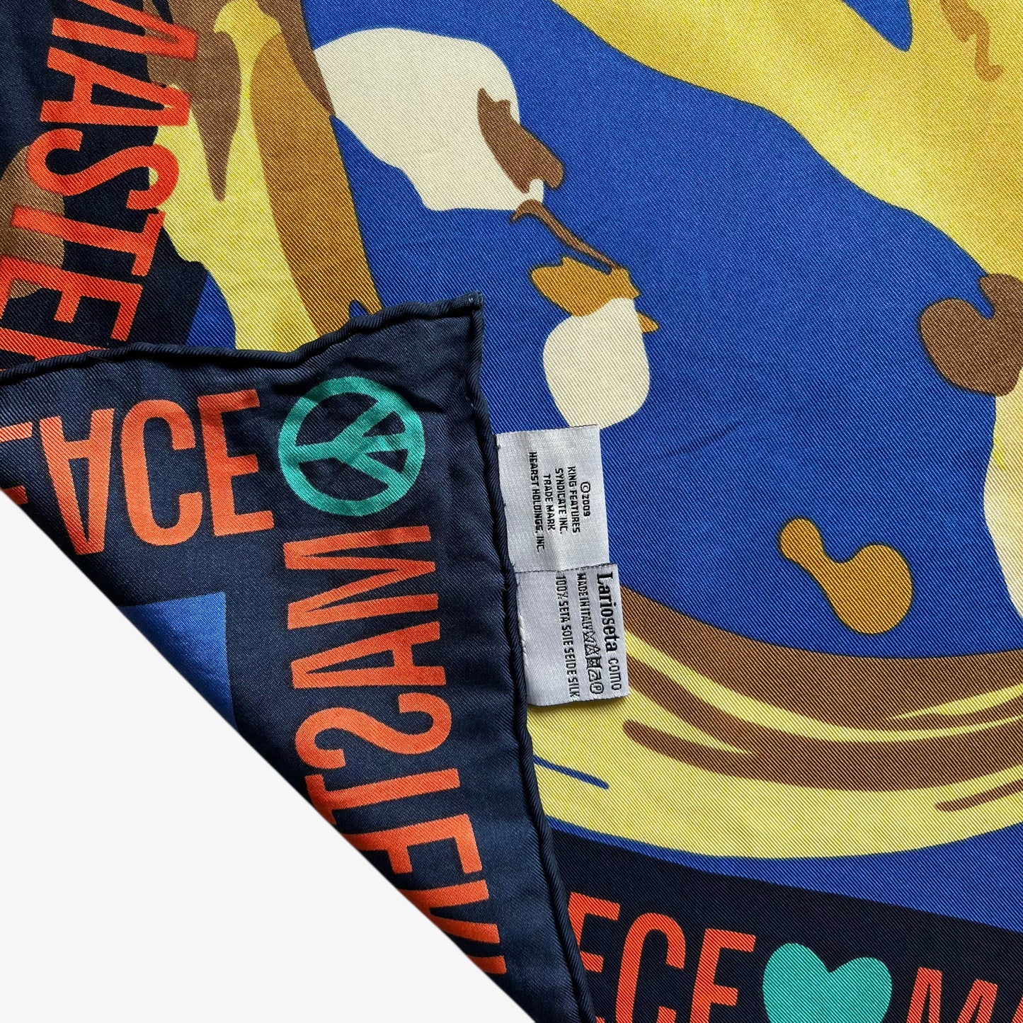 Hand rolled edges of women's vintage Y2K Moschino abstract master peace sign and heart oil painting print blue silk scarf.
