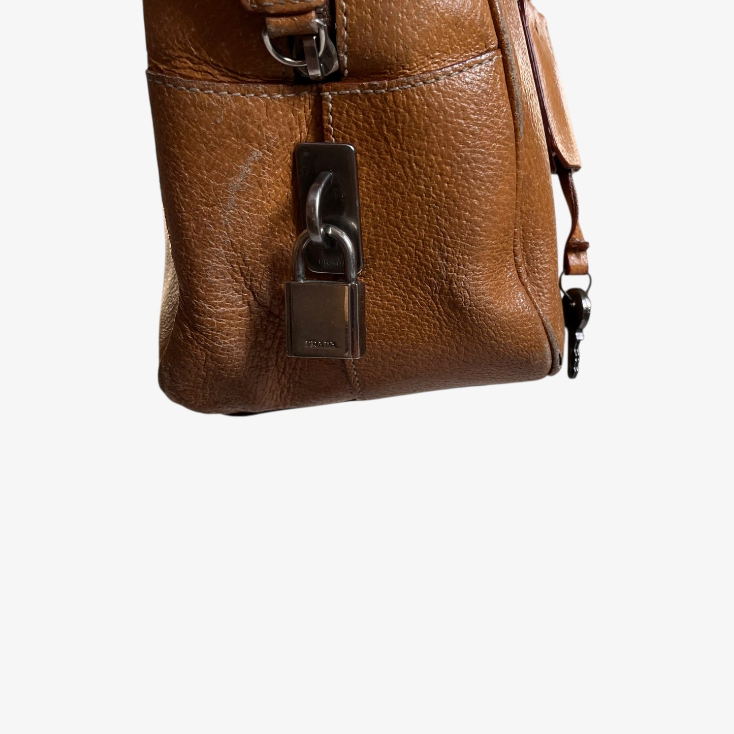 Prada lock and key charm on the side of vintage Y2K Cinghiale sport brown leather Bauletto shoulder bag.