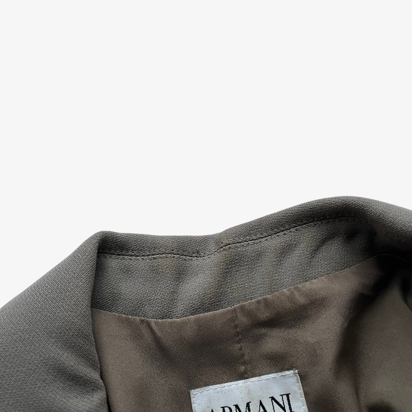 Close up of wear on collar of a vintage Y2K women's Armani Collezioni grey single breasted blazer.