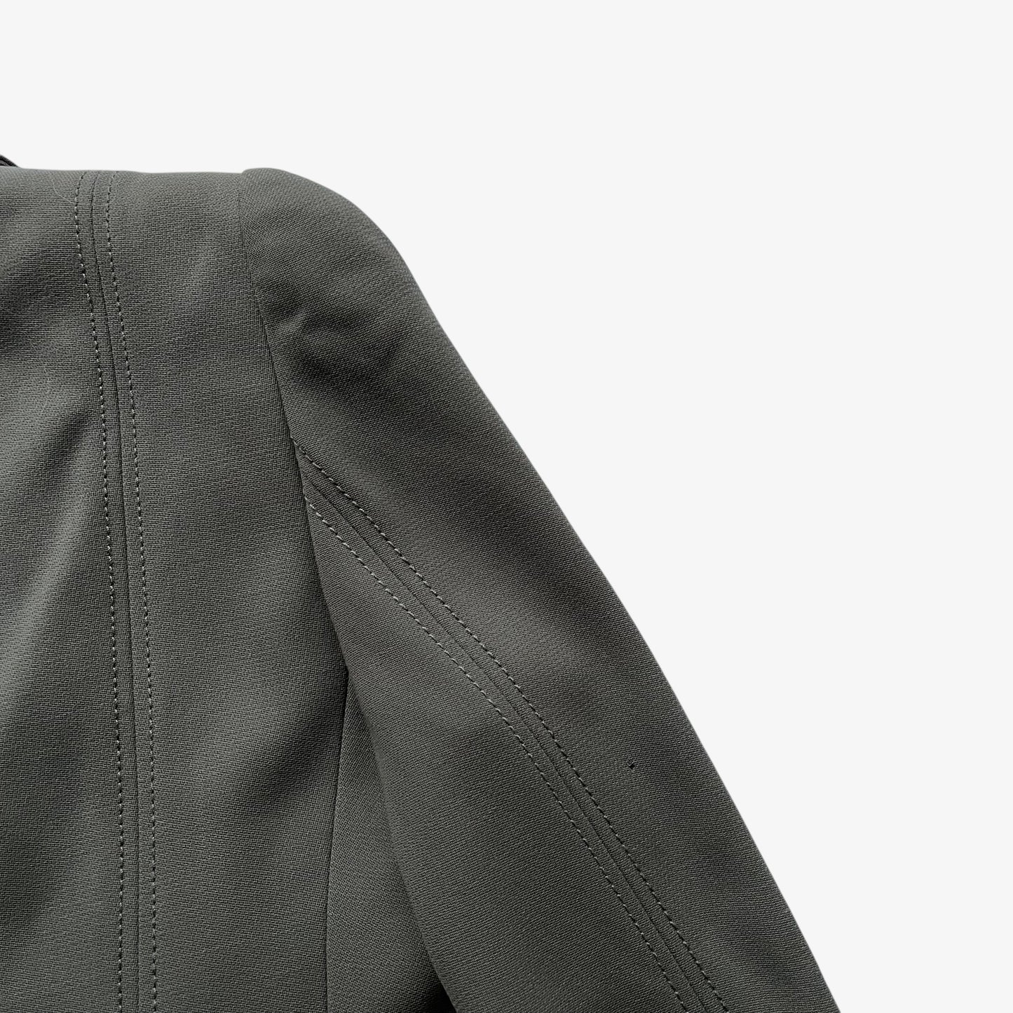 Close up of detailed stitching on the back of a vintage Y2K women's Armani Collezioni grey single breasted blazer.