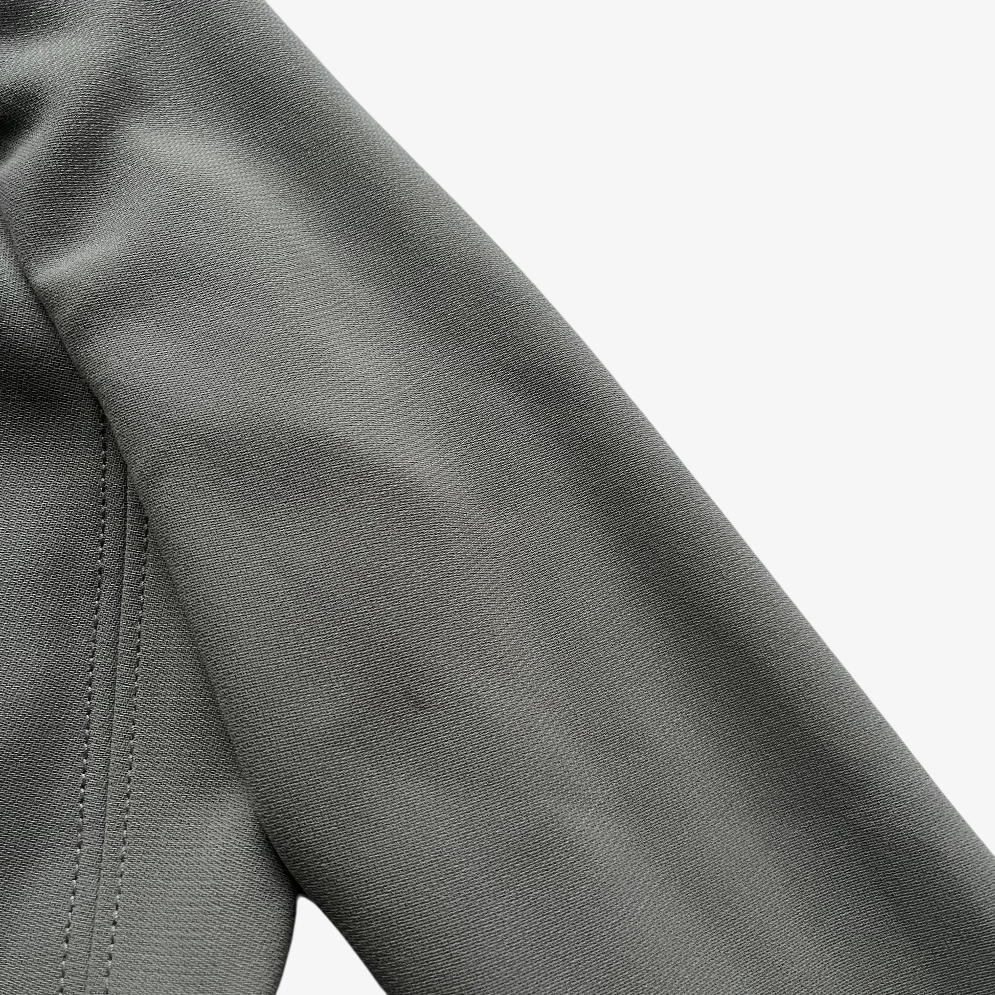 Wear on the arm of a vintage Y2K women's Armani Collezioni grey single breasted blazer.