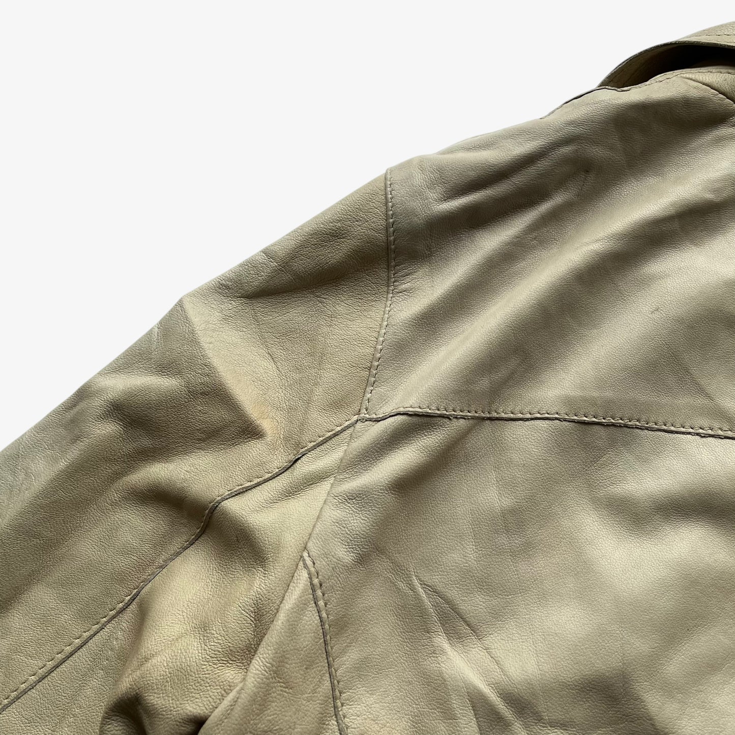 Patina on shoulder of women's vintage Y2K Armani Jeans cream leather blazer.