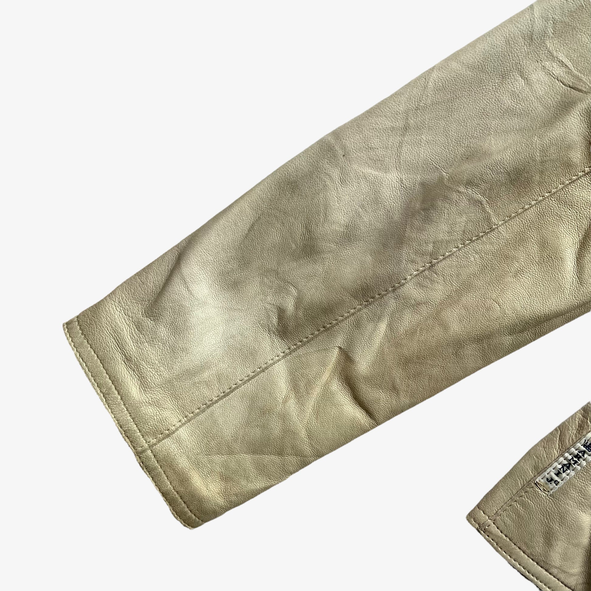 Patina on sleeve of women's vintage Y2K Armani Jeans cream leather blazer.