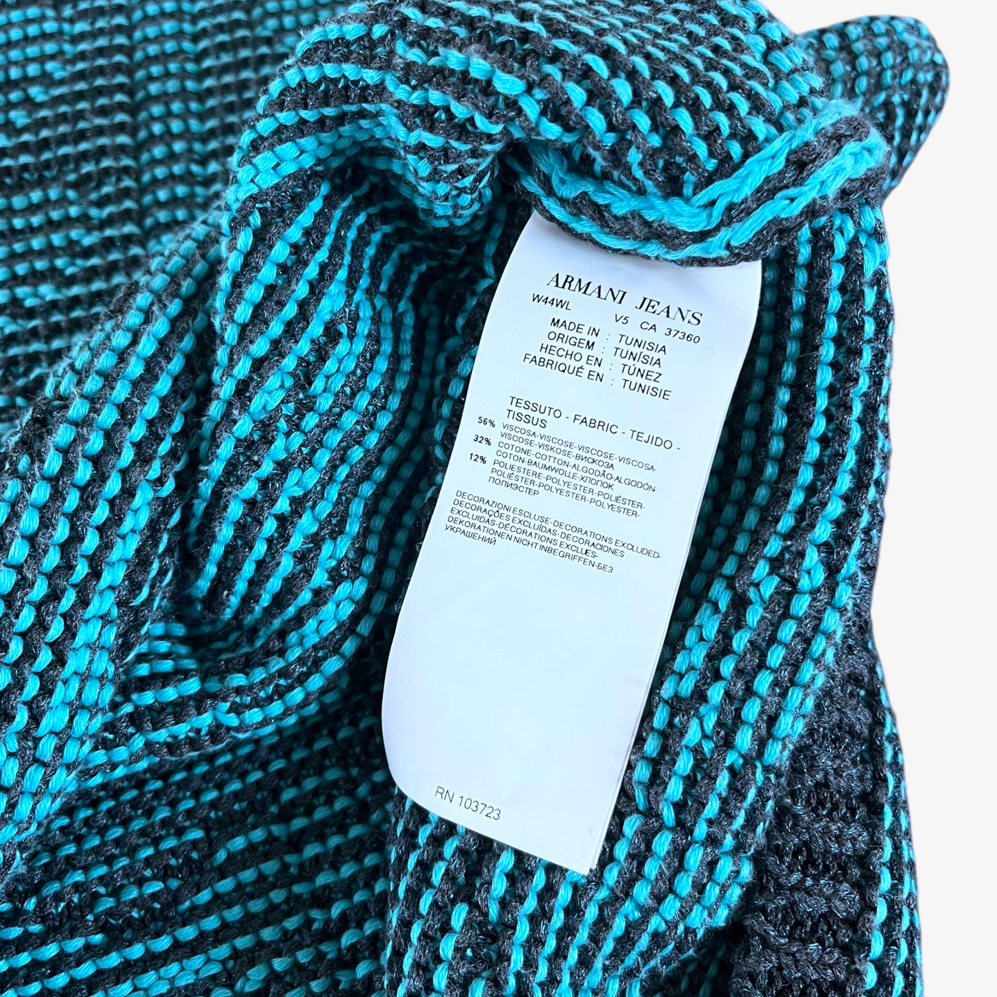 Material label of vintage Y2K Armani Jeans women’s blue knitted short sleeve top.