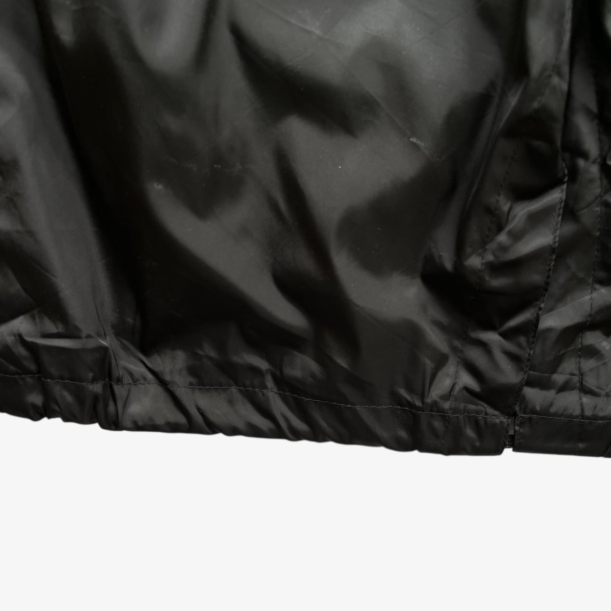 Hem of vintage Y2K women's Burberry black hooded jacket.