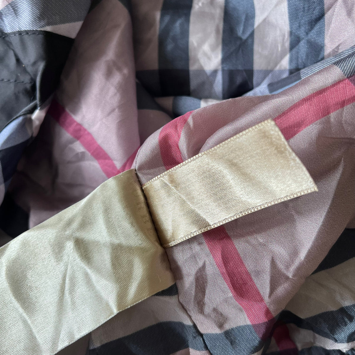 Nova check lining of vintage Y2K women's Burberry black hooded jacket.