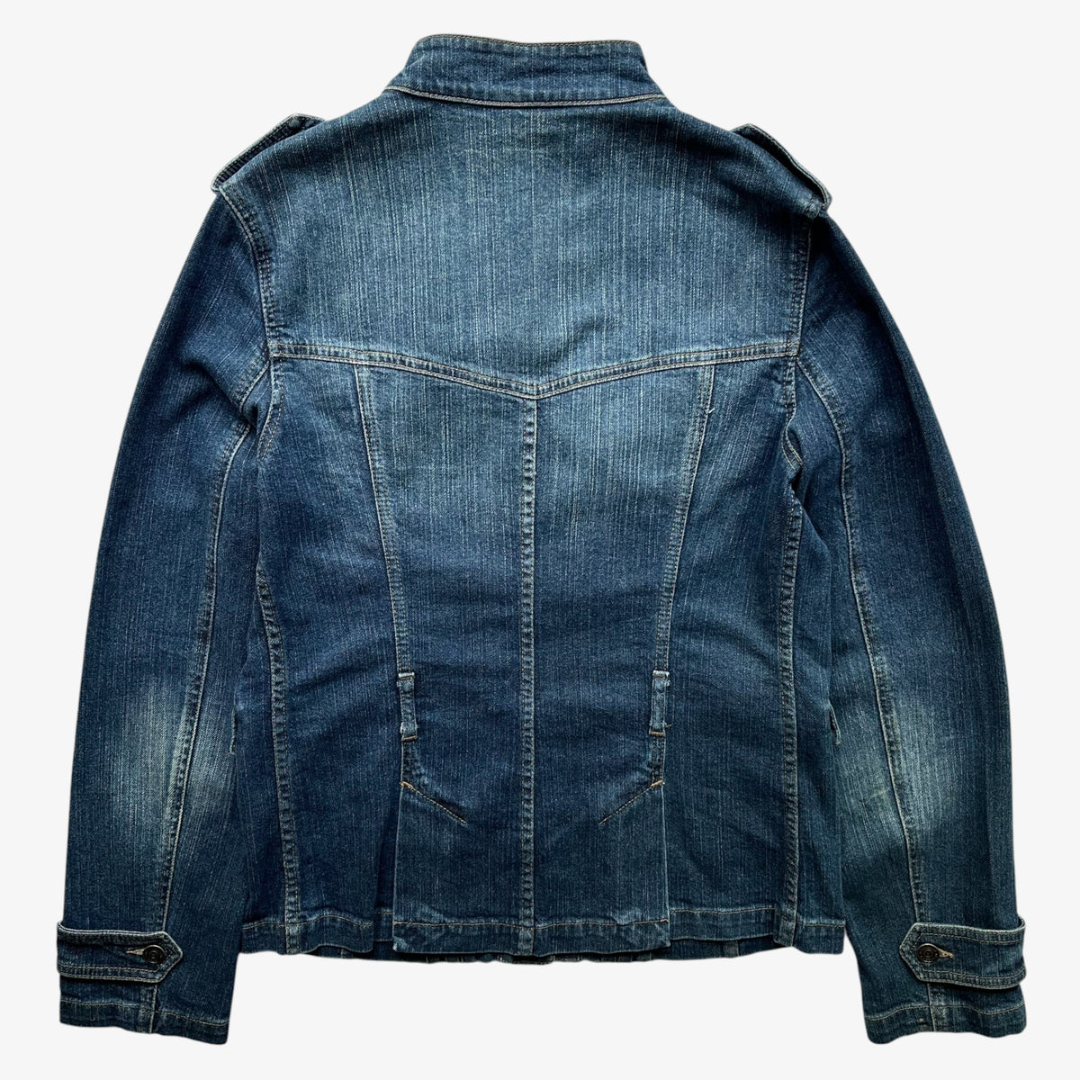 The back view of a vintage women's Burberry blue military denim jacket with a high collar, shoulder epaulets, and front seam detailing, shown on a plain white background.
