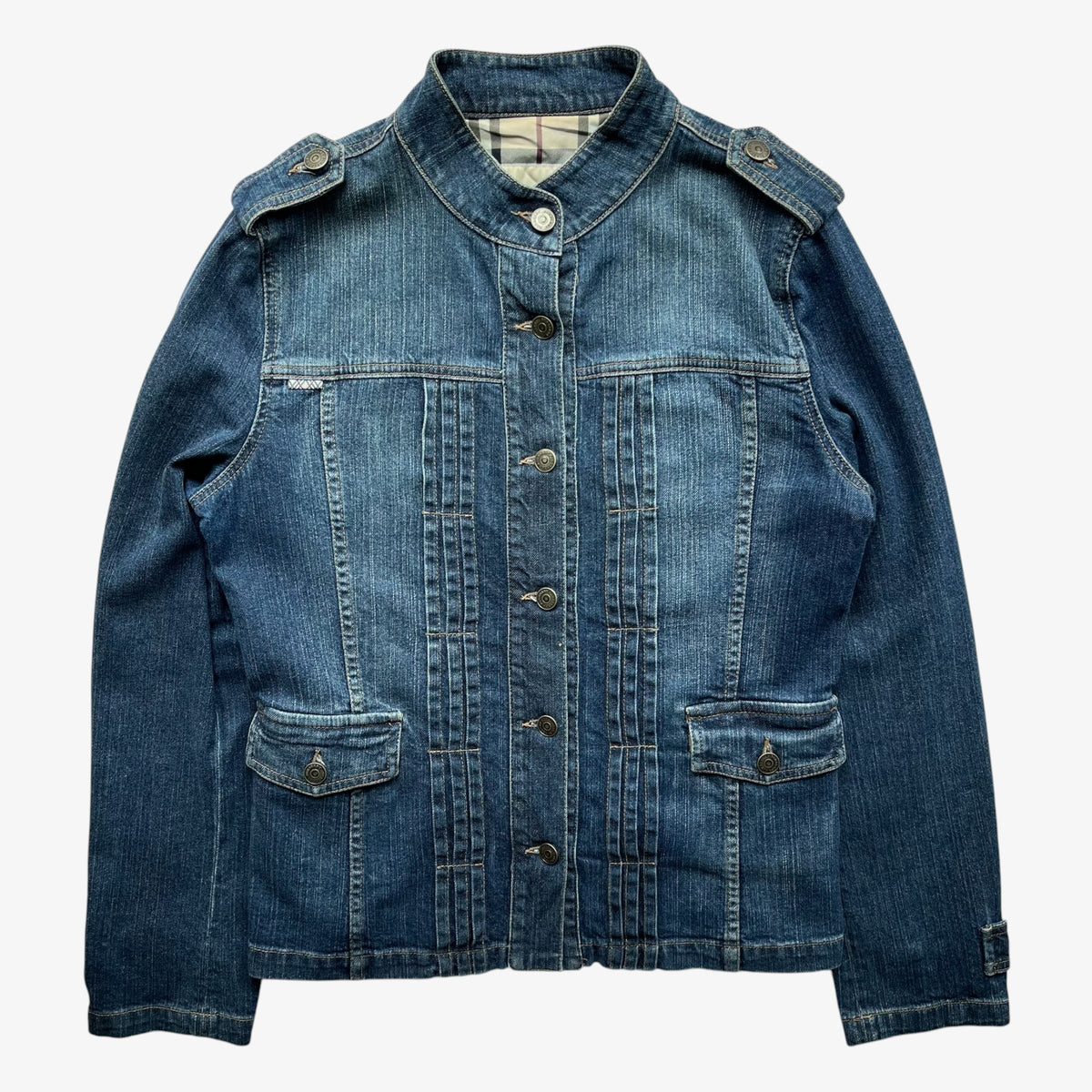 A vintage women's Burberry blue military denim jacket with a high stand-up collar, button front, and flap pockets, shown flat against a light grey background.