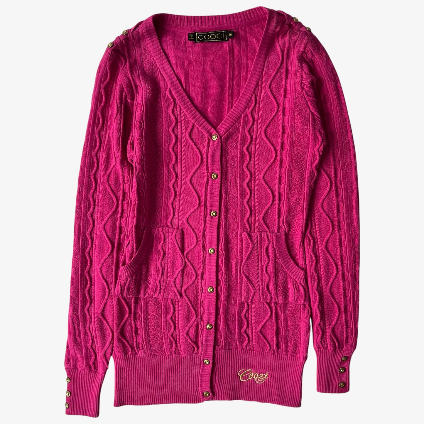 Vintage Coogi pink women's cardigan with cable knit pattern on a white background.