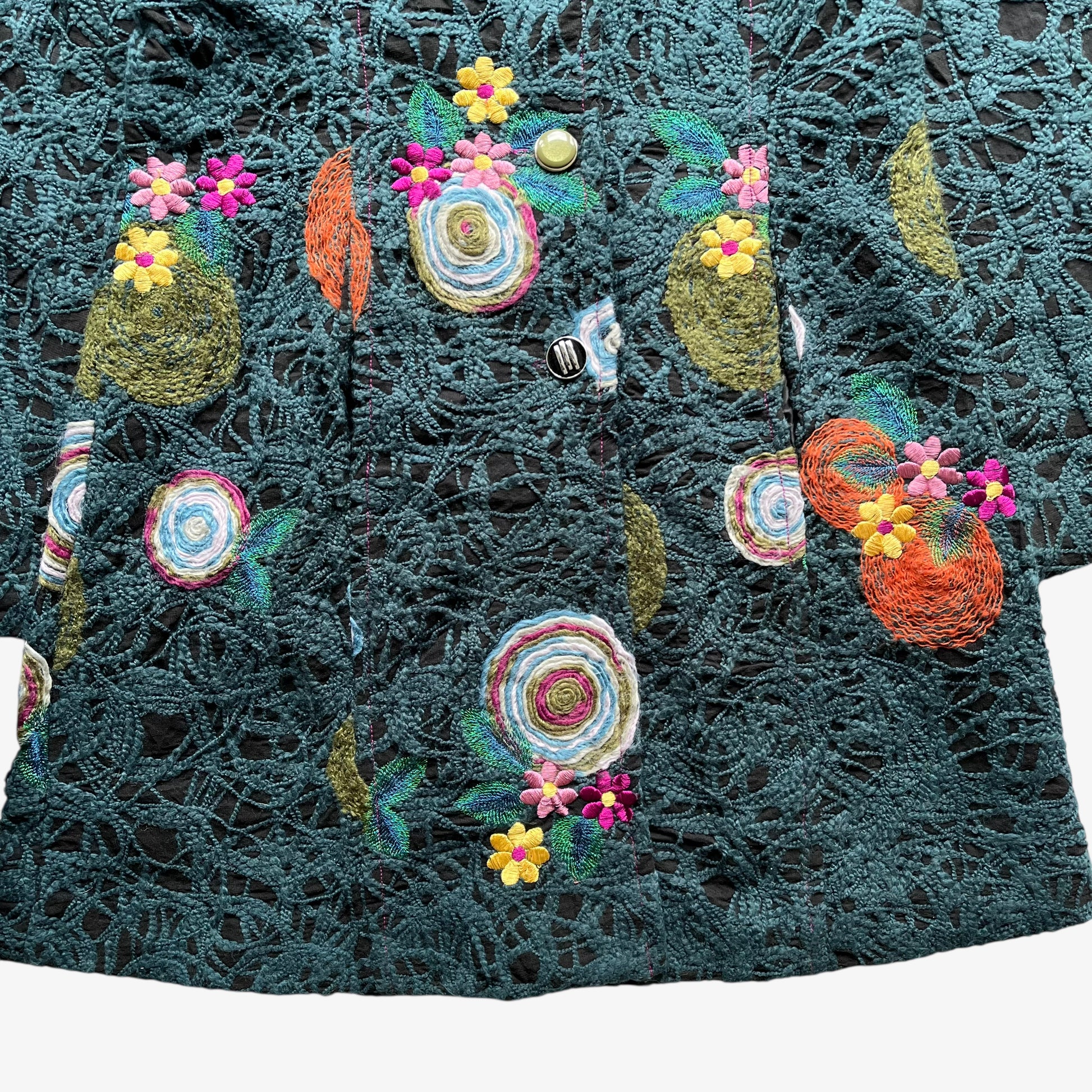 Hem of vintage Y2K women's Desigual abstract floral embroidered green coat.