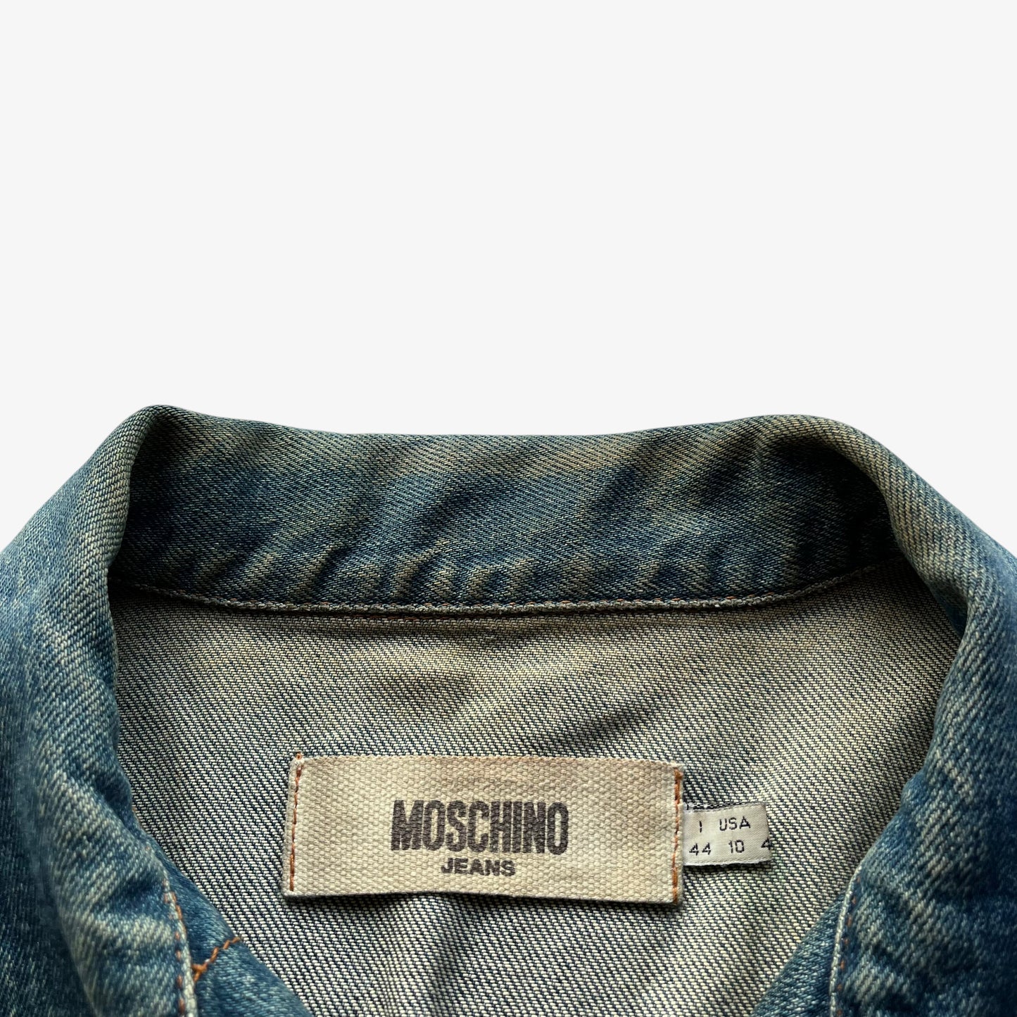 Moschino jeans label stitched inside of vintage Y2K women's blue denim trucker jacket.
