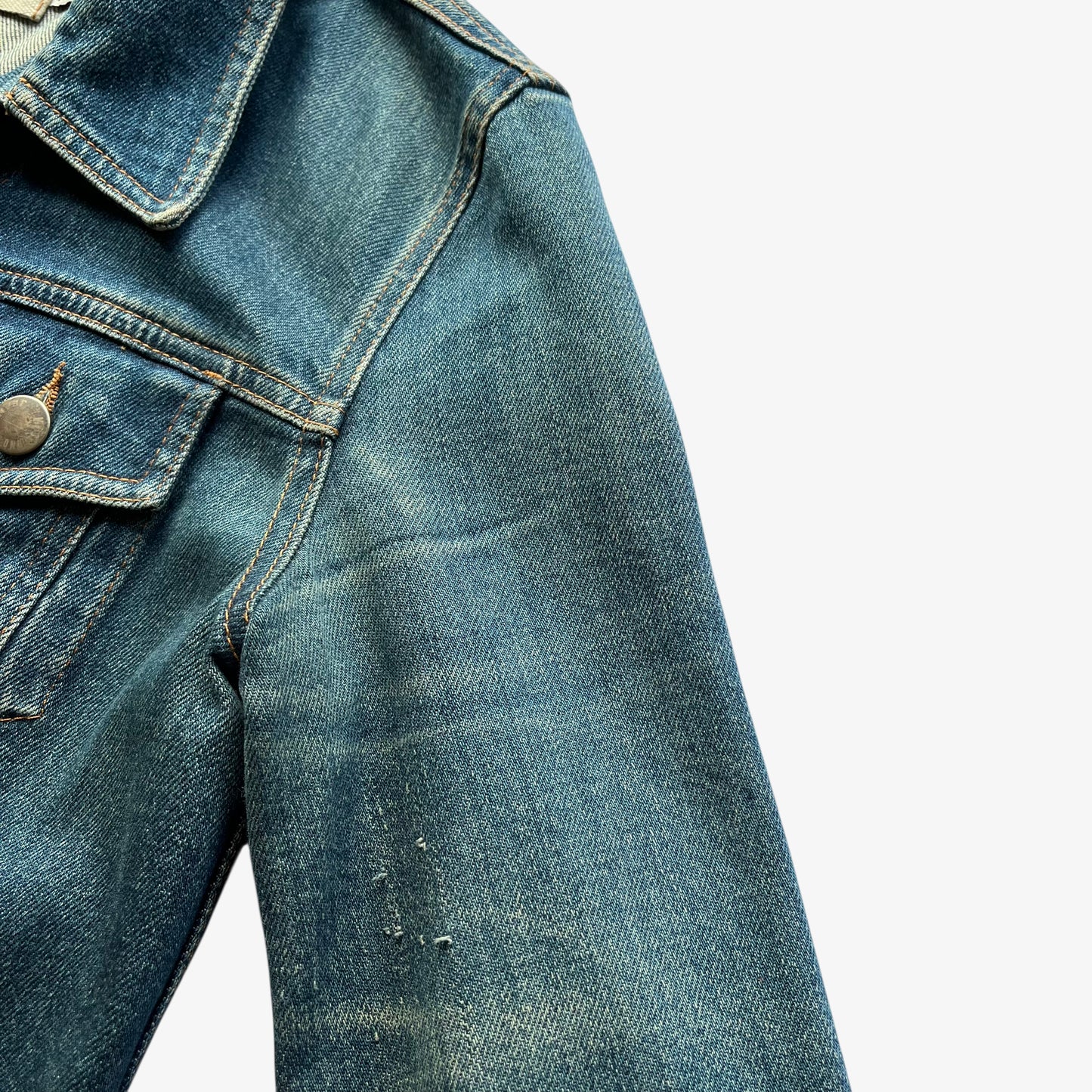 Patina on vintage Y2K women's Moschino jeans blue denim trucker jacket.