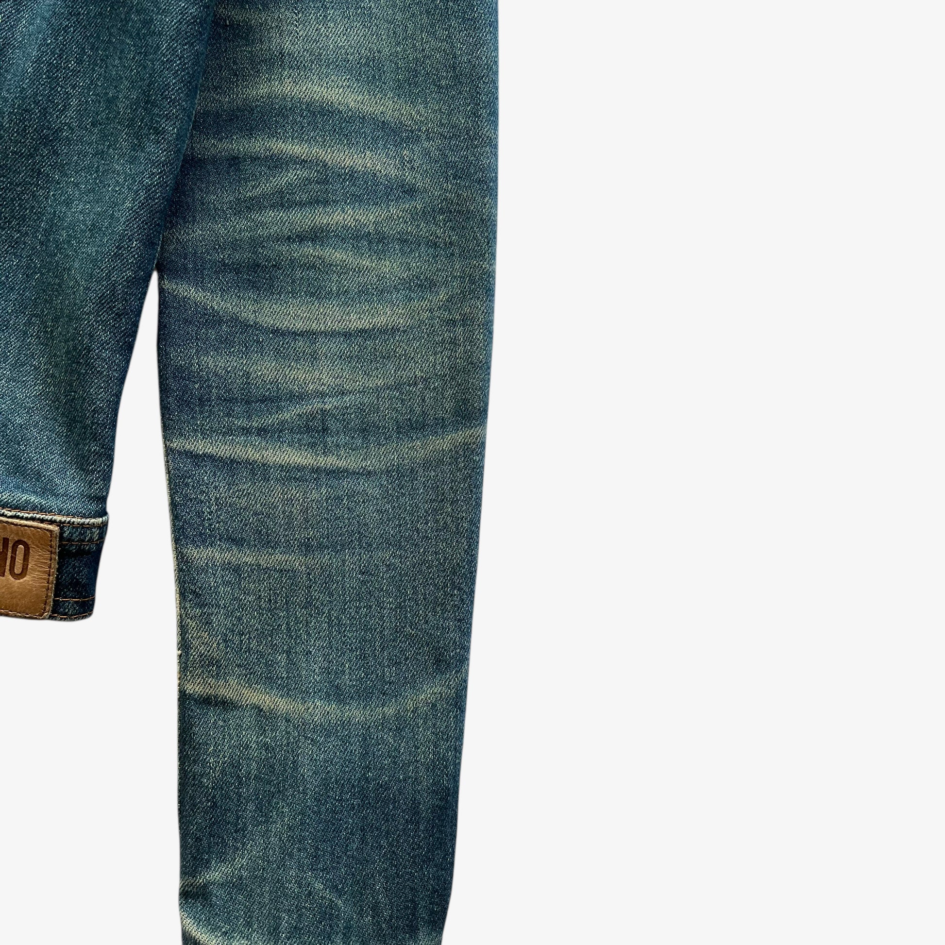 Sleeve of vintage Y2K women's Moschino jeans blue denim trucker jacket.