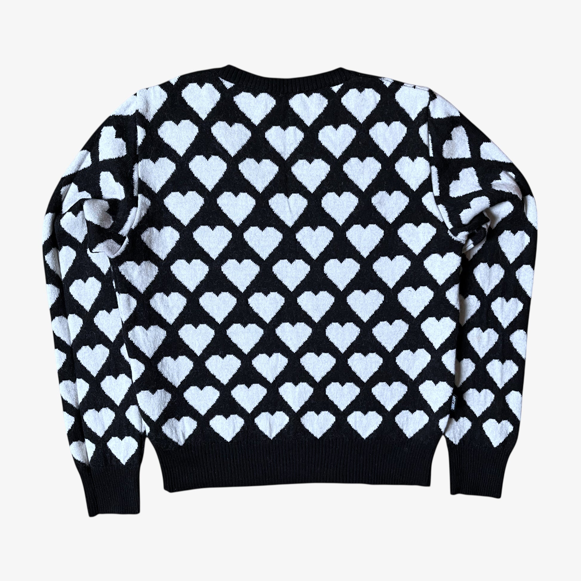Back of vintage Y2K Moschino Jeans women's black and white v-neck wool jumper with heart pattern.