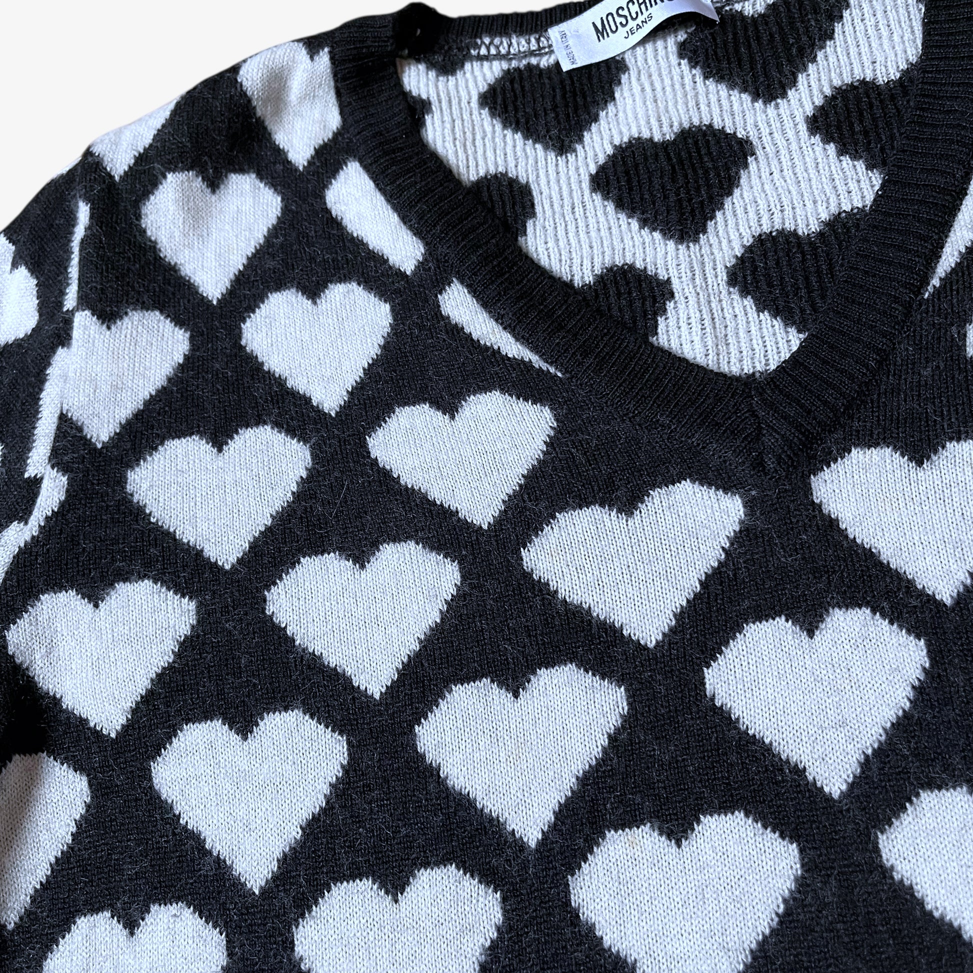 Close up of vintage Y2K Moschino Jeans women's black and white v-neck wool jumper with heart pattern.