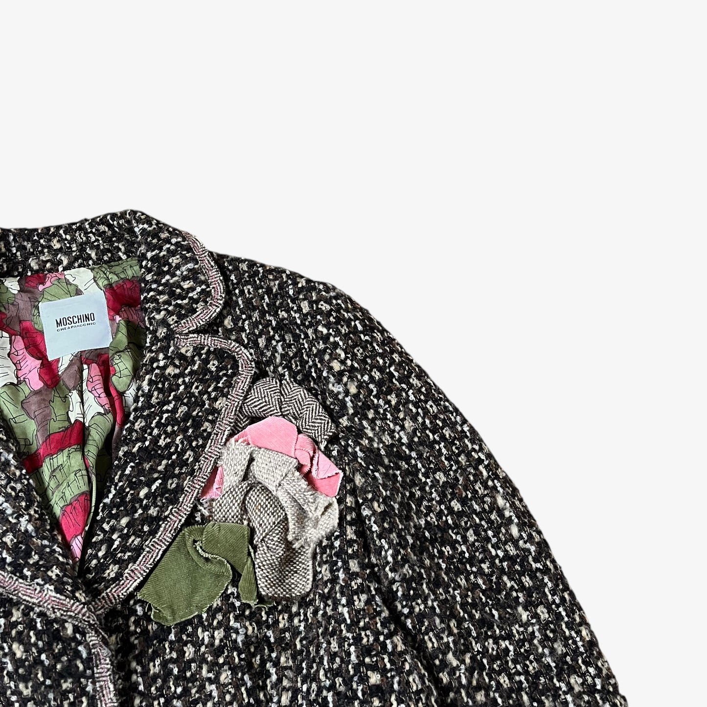Close up of floral embroidered design on vintage Y2K women's Moschino textured wool and mohair single breasted blazer.