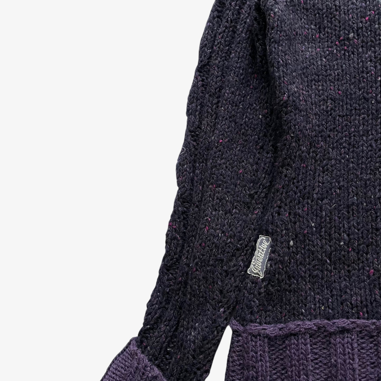 Inventive tag stitched onto the hem of a women's Napapijri purple wool turtleneck jumper.