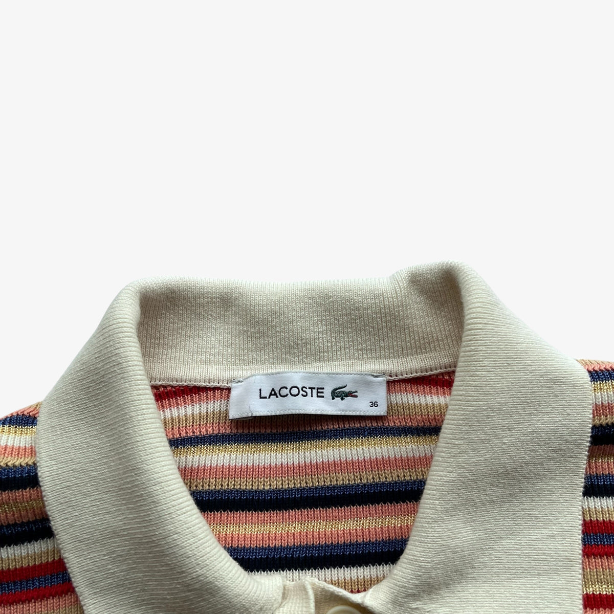 Close up of Lacoste label stitched inside a knitted women's polo shirt.